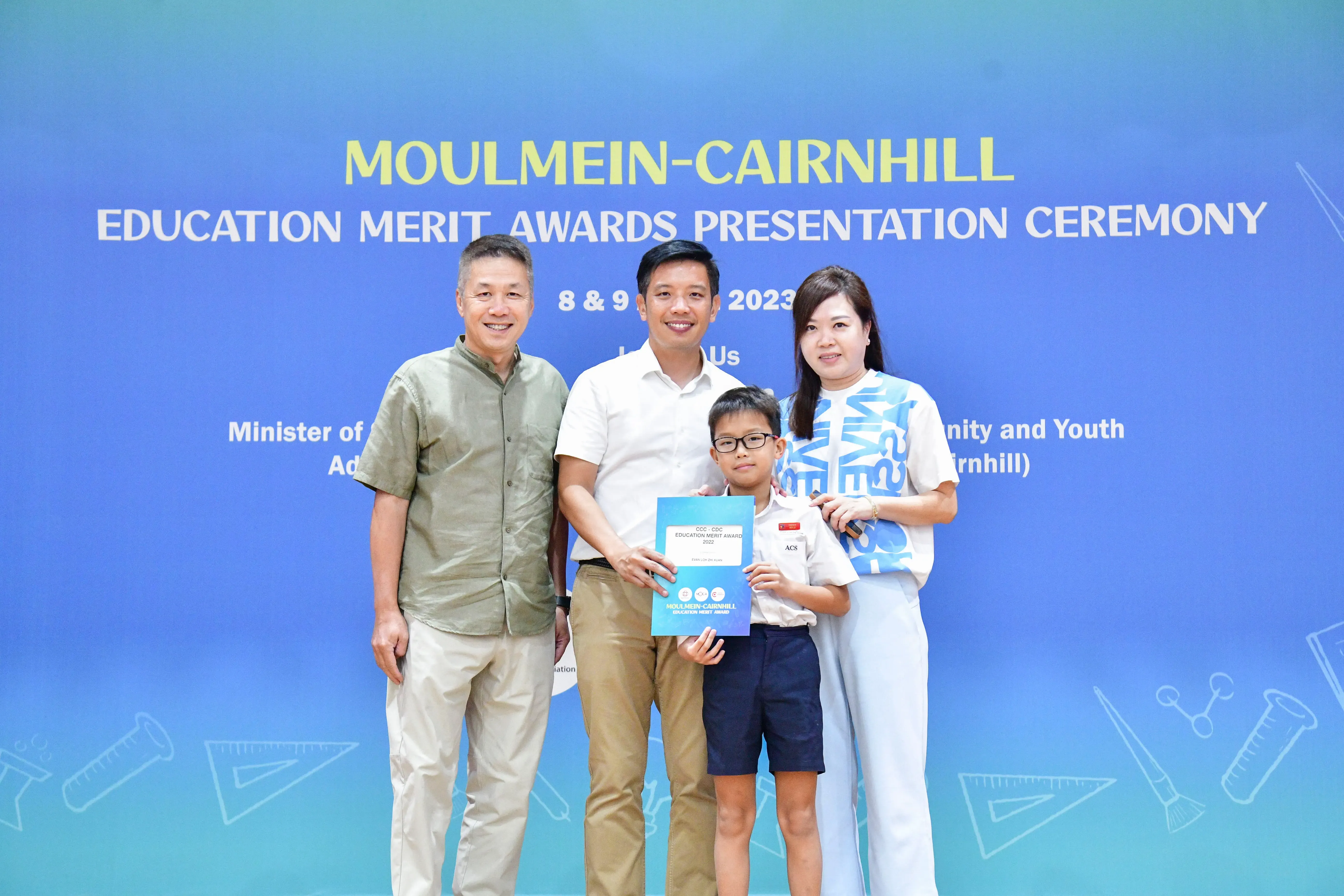 Three adults and a young boy holding an award certificate pose at the Moulmein-Cairnhill Education Merit Awards 2023.