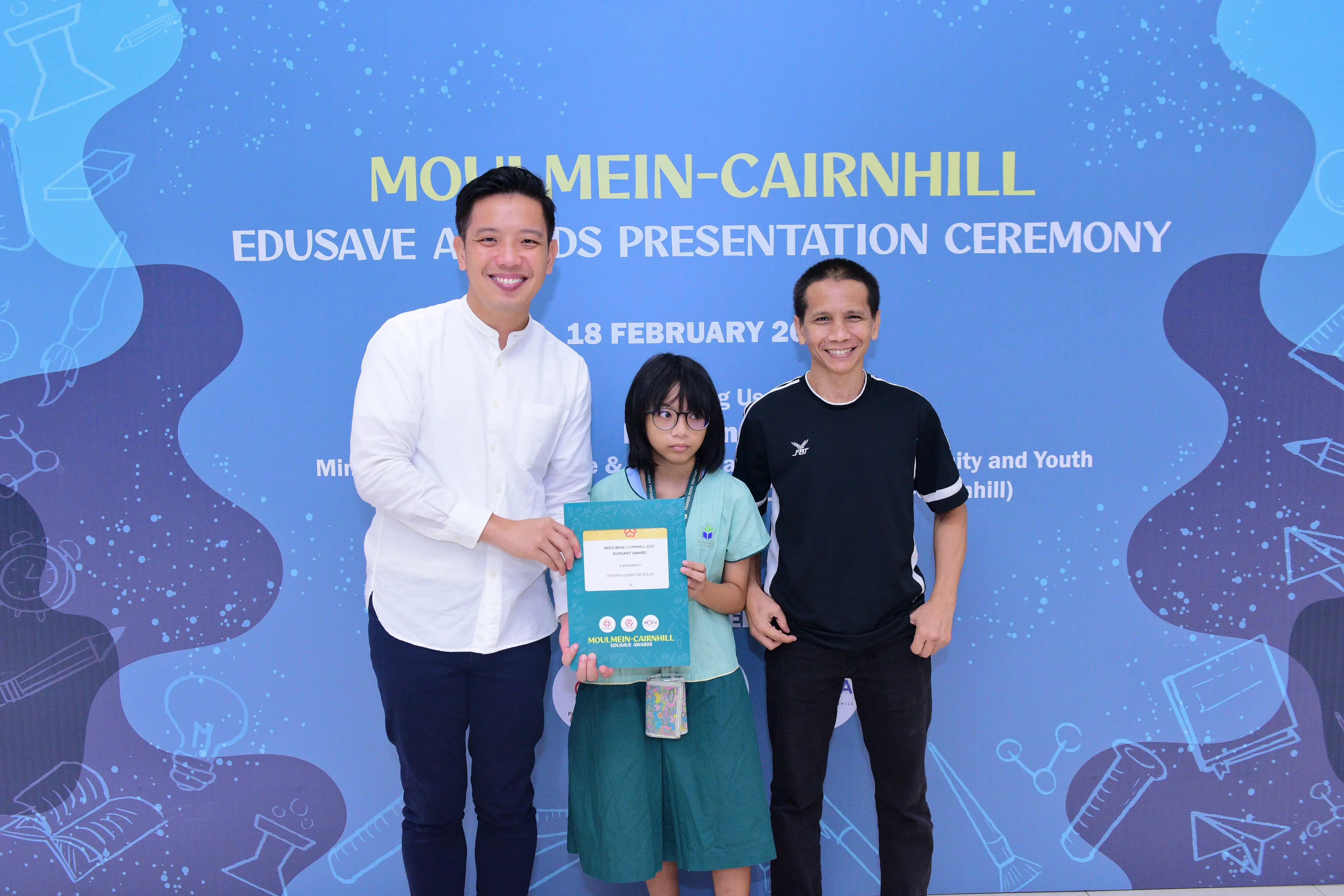 Three people pose with a certificate at the Moulmein-Cairnhill Edusave Awards Presentation Ceremony on 18 February.