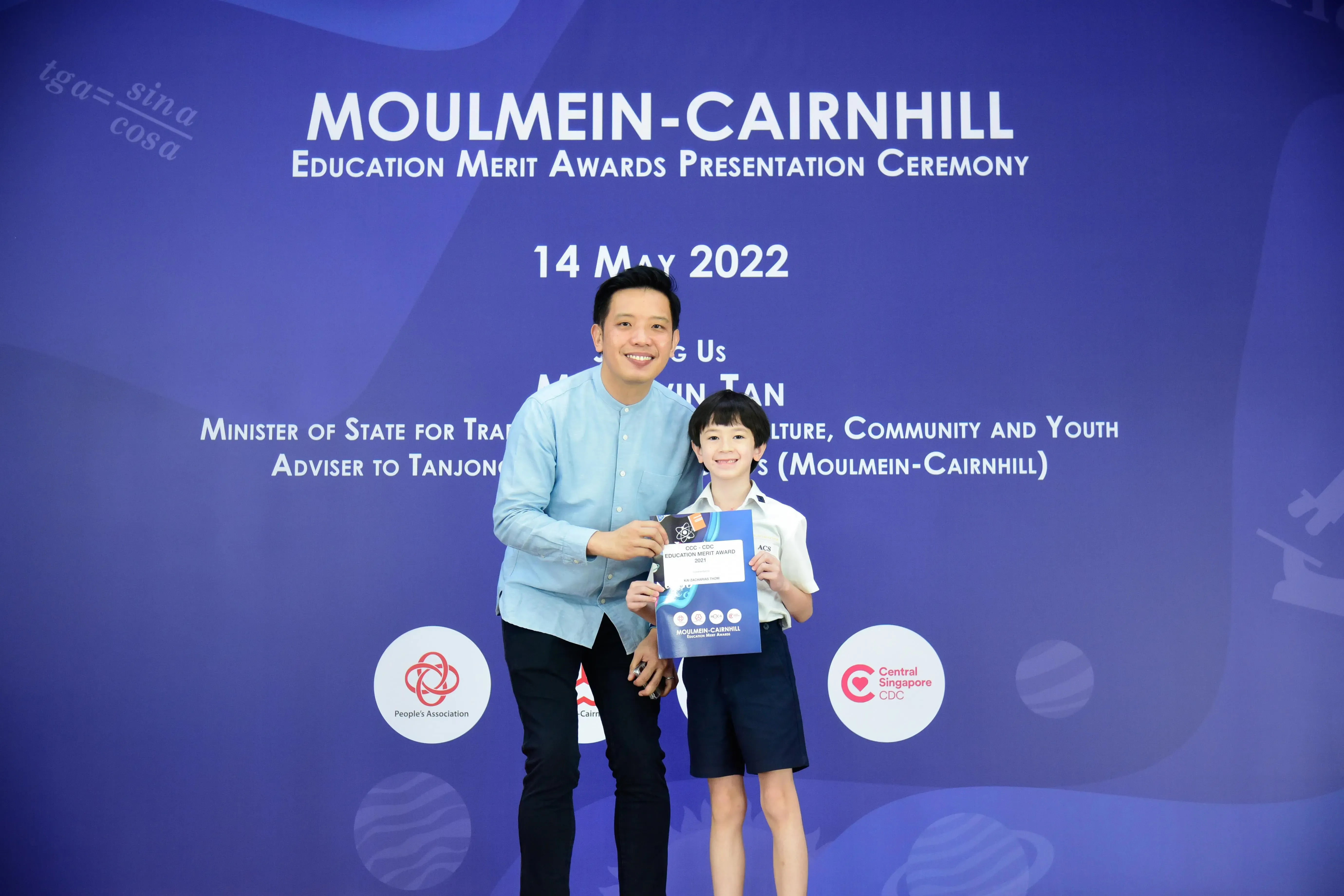 A man and a young boy pose together holding an award at the Moulmein-Cairnhill Education Merit Awards on 14 May 2022.