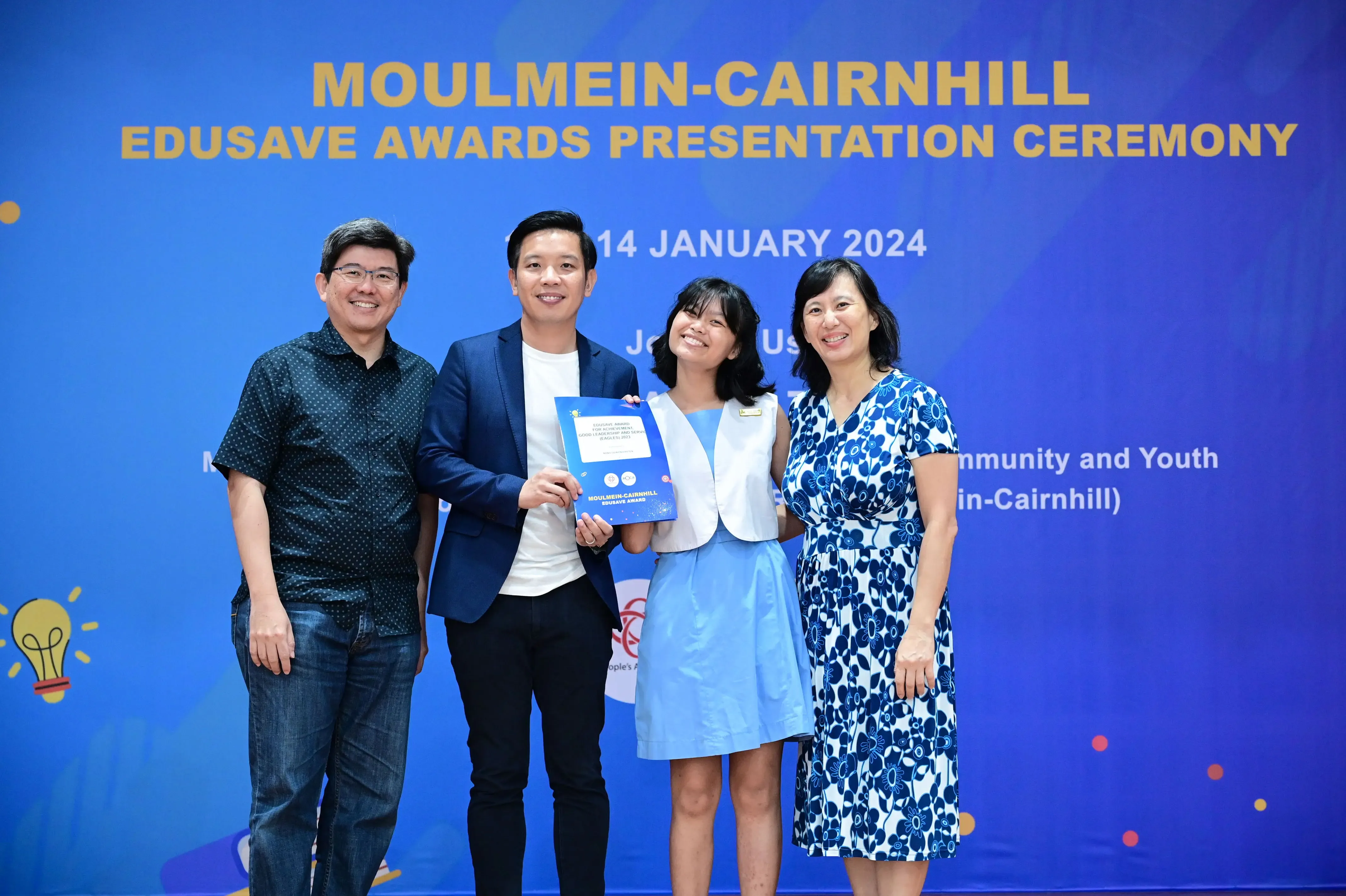 Four smiling people pose at the Moulmein-Cairnhill Edusave Awards Presentation Ceremony on 14 January 2024.