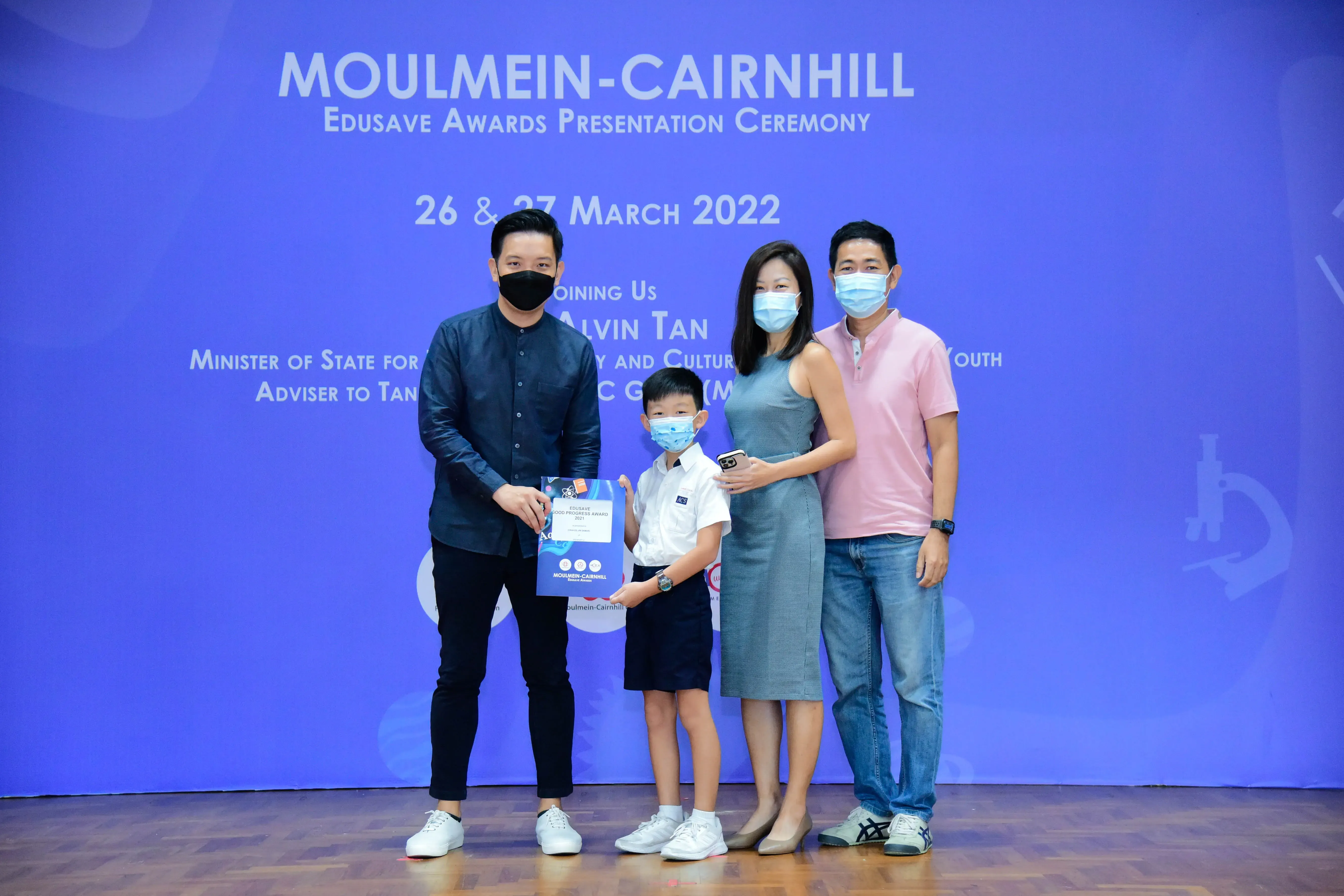Four masked people pose at the Moulmein-Cairnhill Edusave Awards Ceremony on 26-27 March 2022.