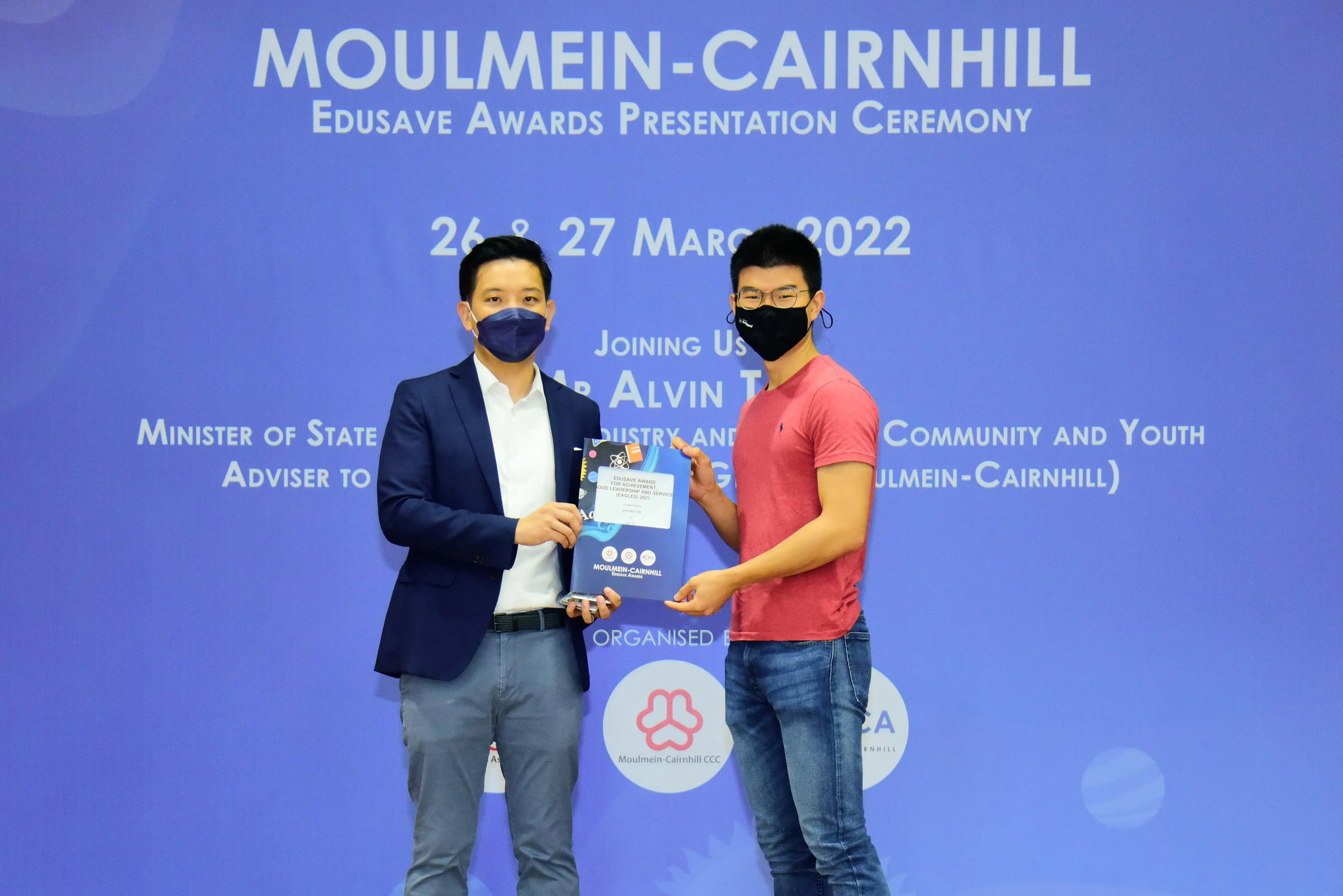 Two masked men present an award at the Moulmein-Cairnhill Edusave Awards Ceremony on 26-27 March 2022.