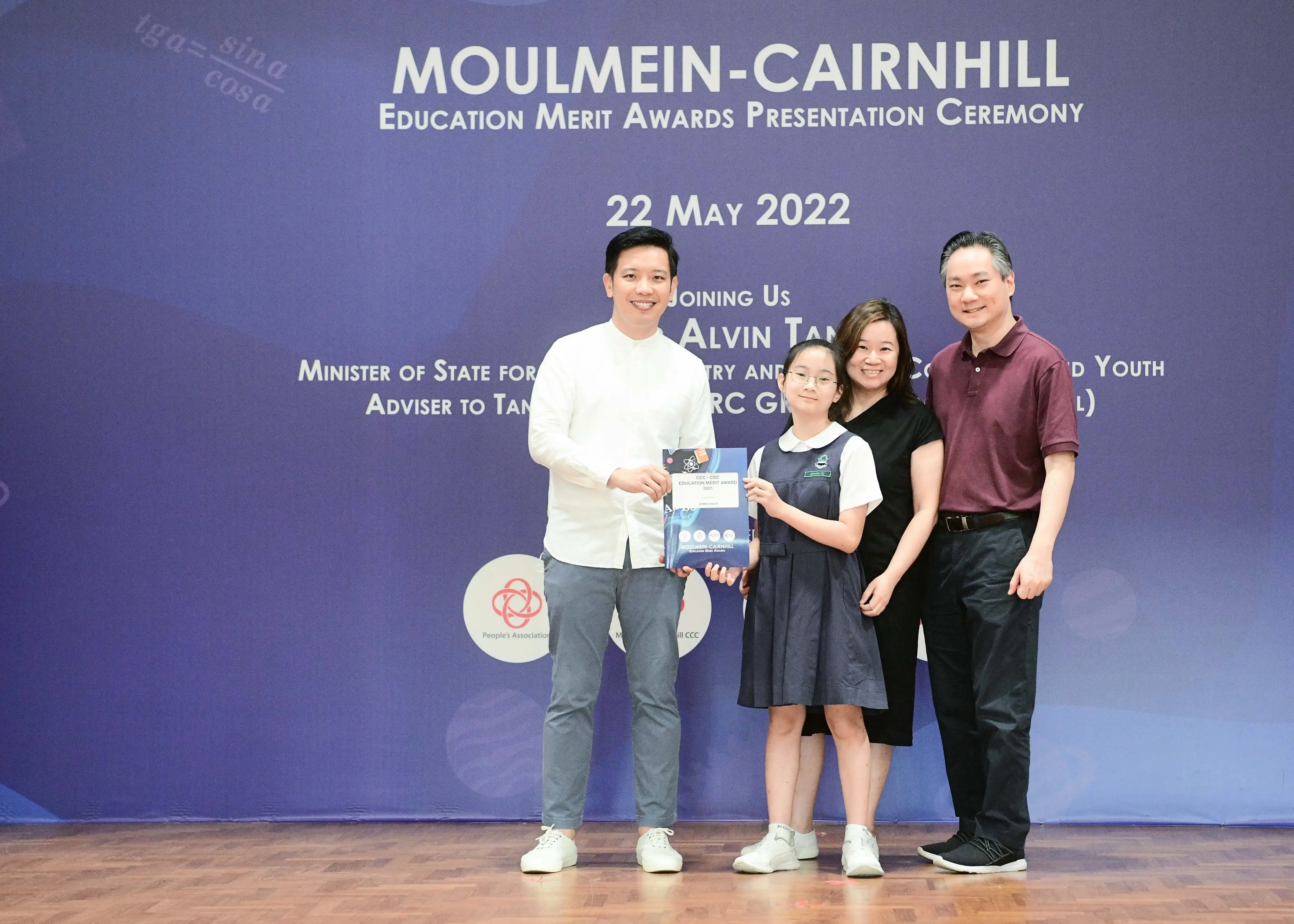Four people pose at the Moulmein-Cairnhill Education Merit Awards Ceremony on 22 May 2022, holding an award.