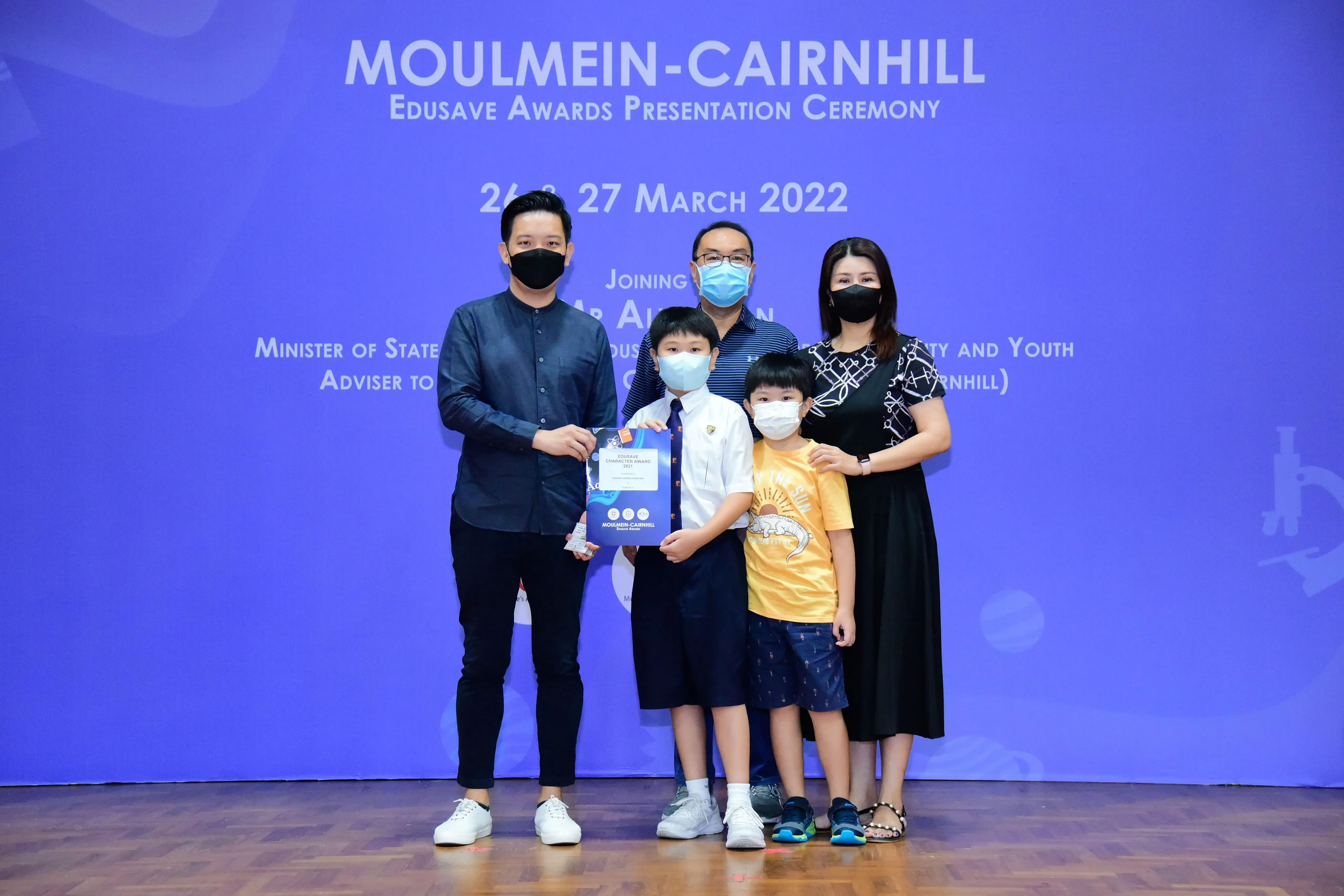 Five masked people pose at the Moulmein-Cairnhill Edusave Awards Ceremony on 26-27 March 2022.