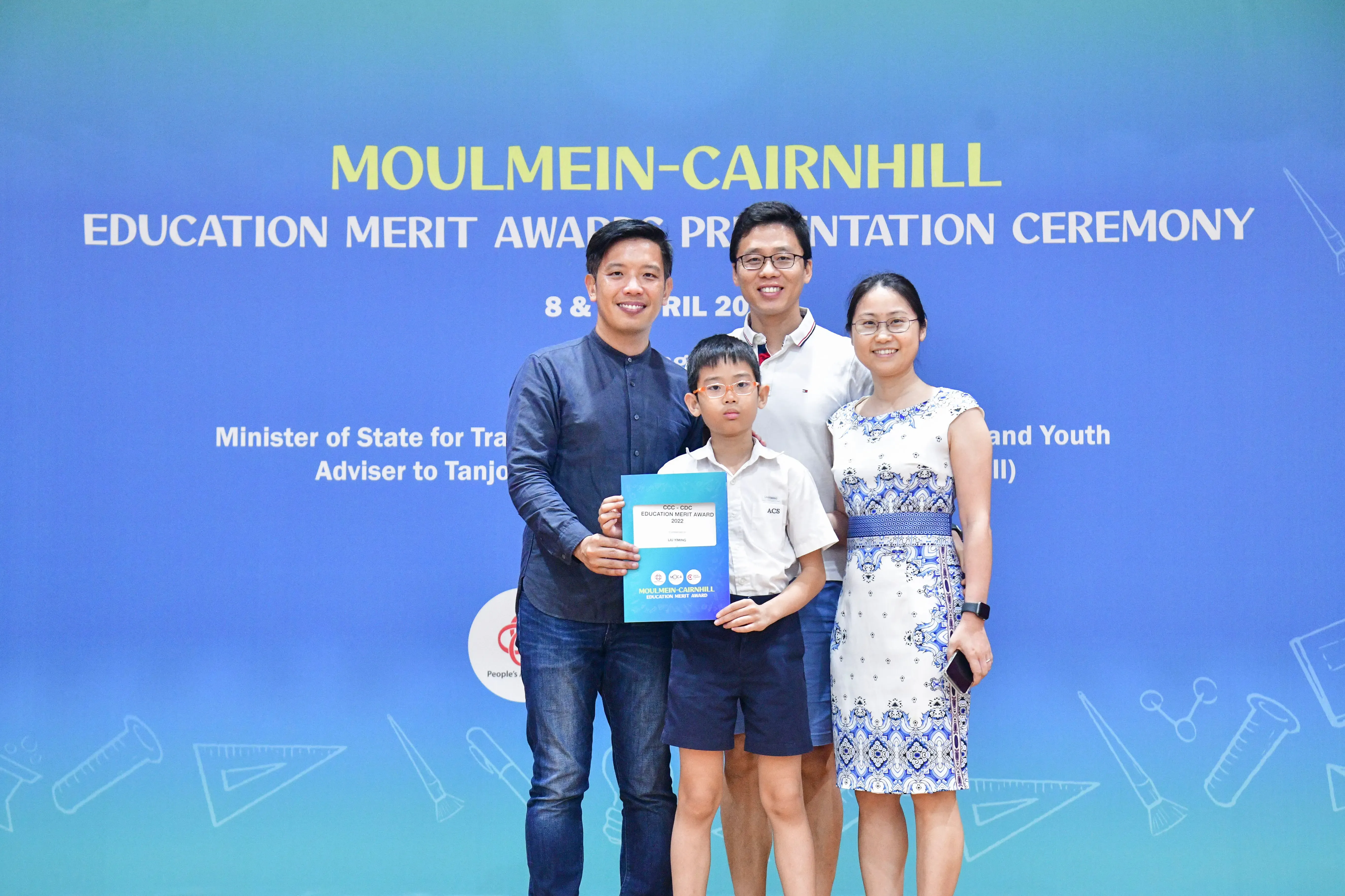 Four people pose with a certificate at the Moulmein-Cairnhill Education Merit Awards Presentation Ceremony.