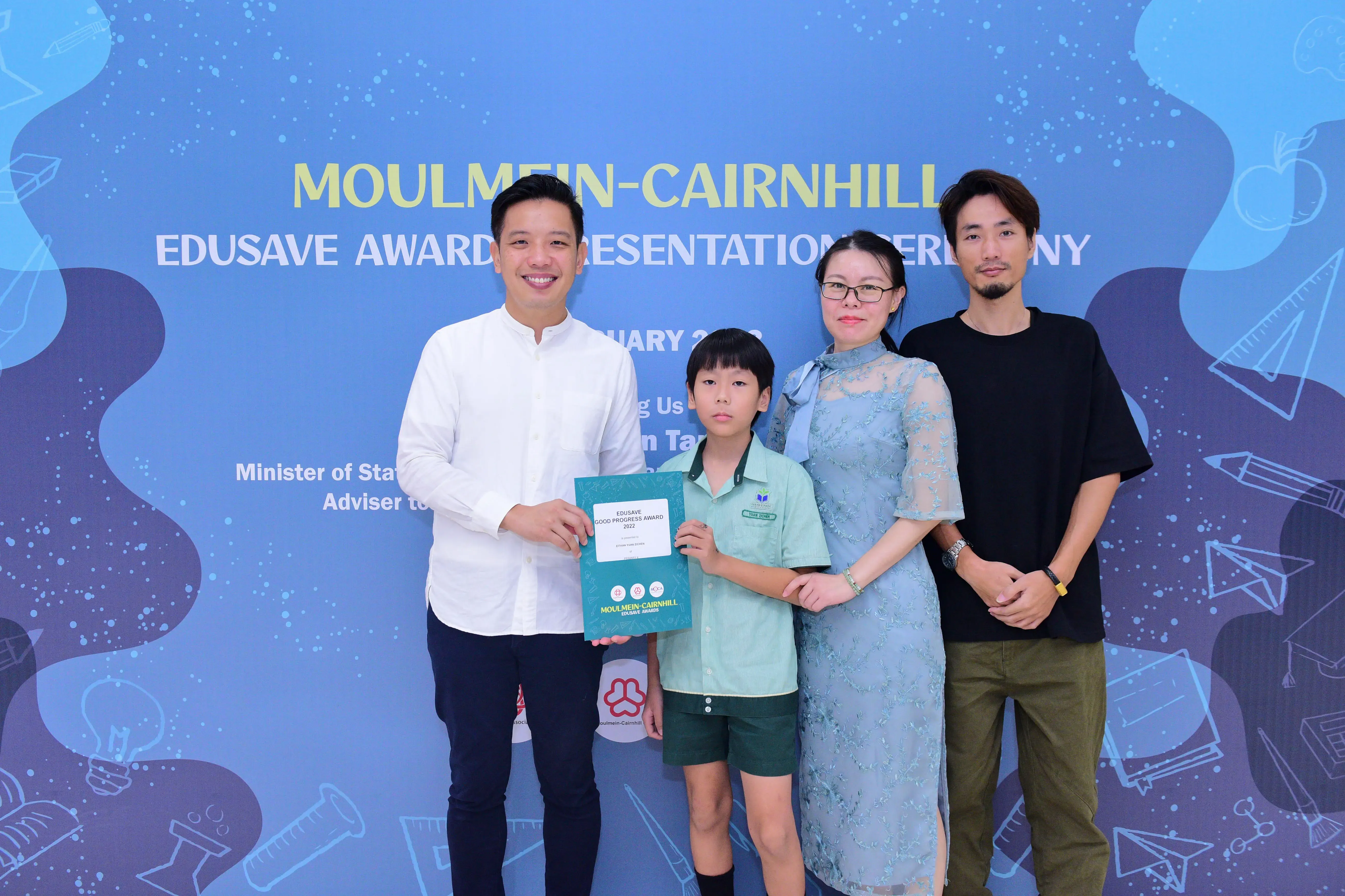 Four people pose with an award certificate at the Moulmein-Cairnhill Edusave Awards Presentation Ceremony.