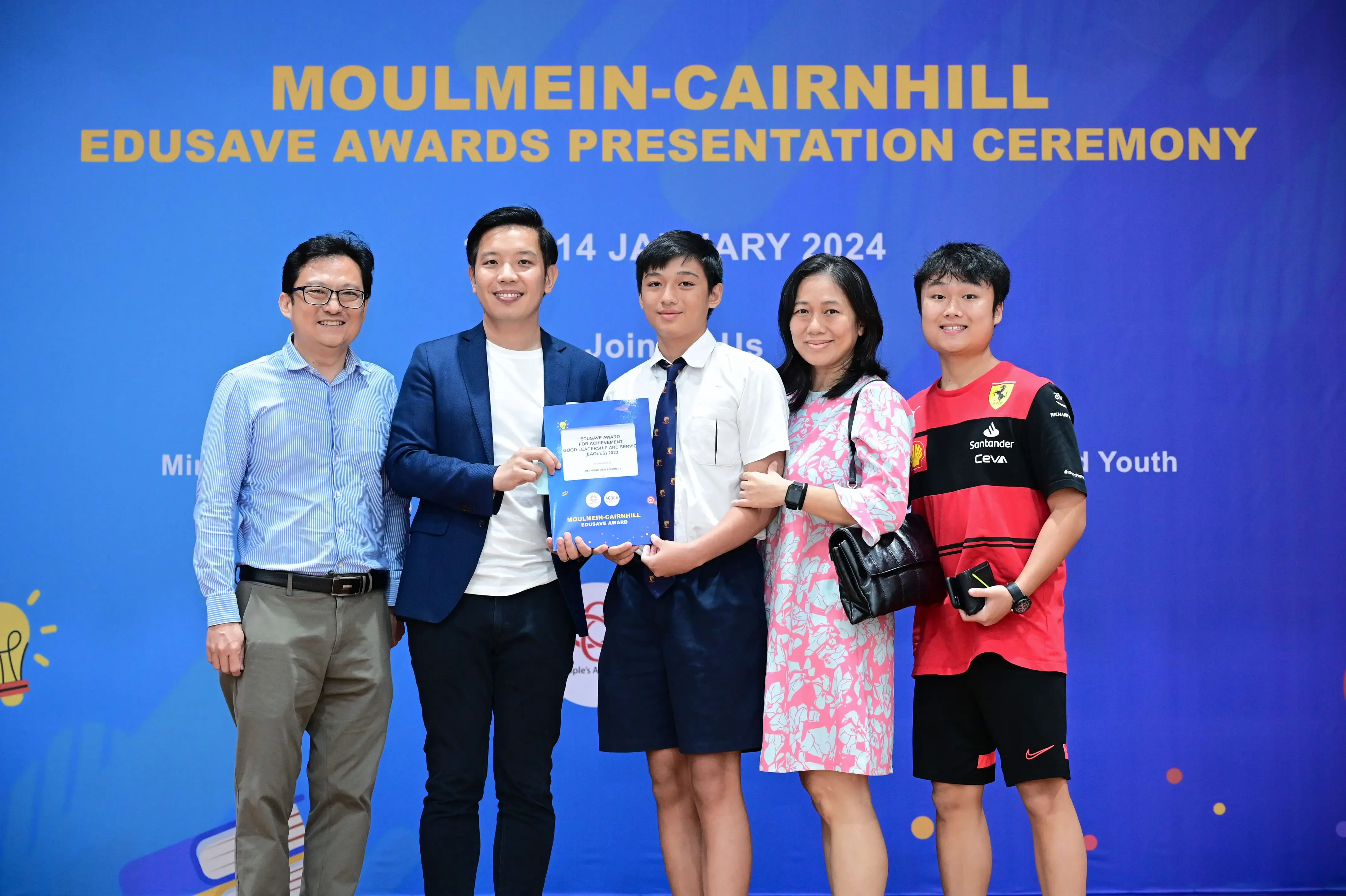 Five people pose holding a certificate at the Moulmein-Cairnhill Edusave Awards Presentation Ceremony on 14 January 2024.