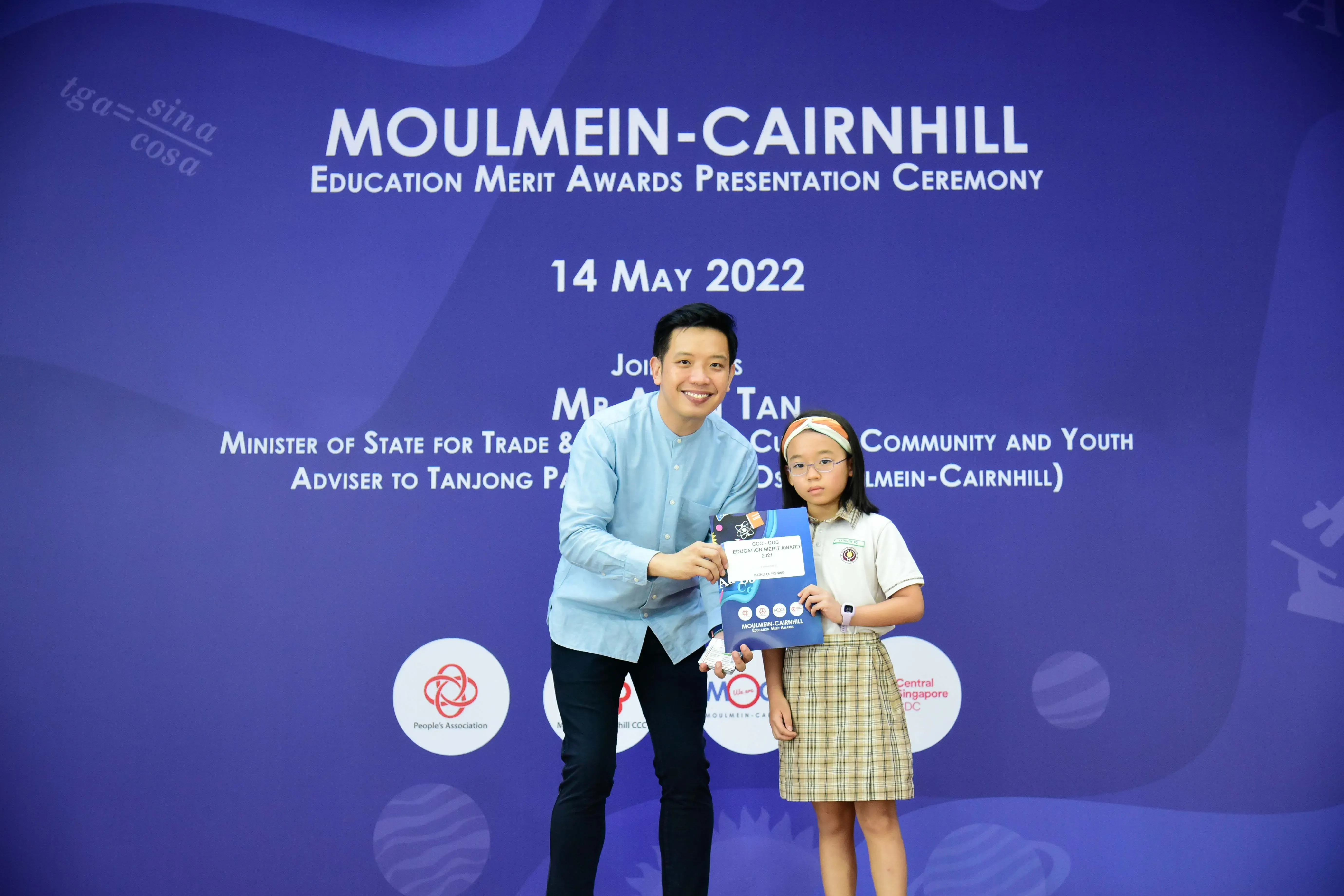 Man and young girl holding an award certificate at the Moulmein-Cairnhill Education Merit Awards on 14 May 2022.