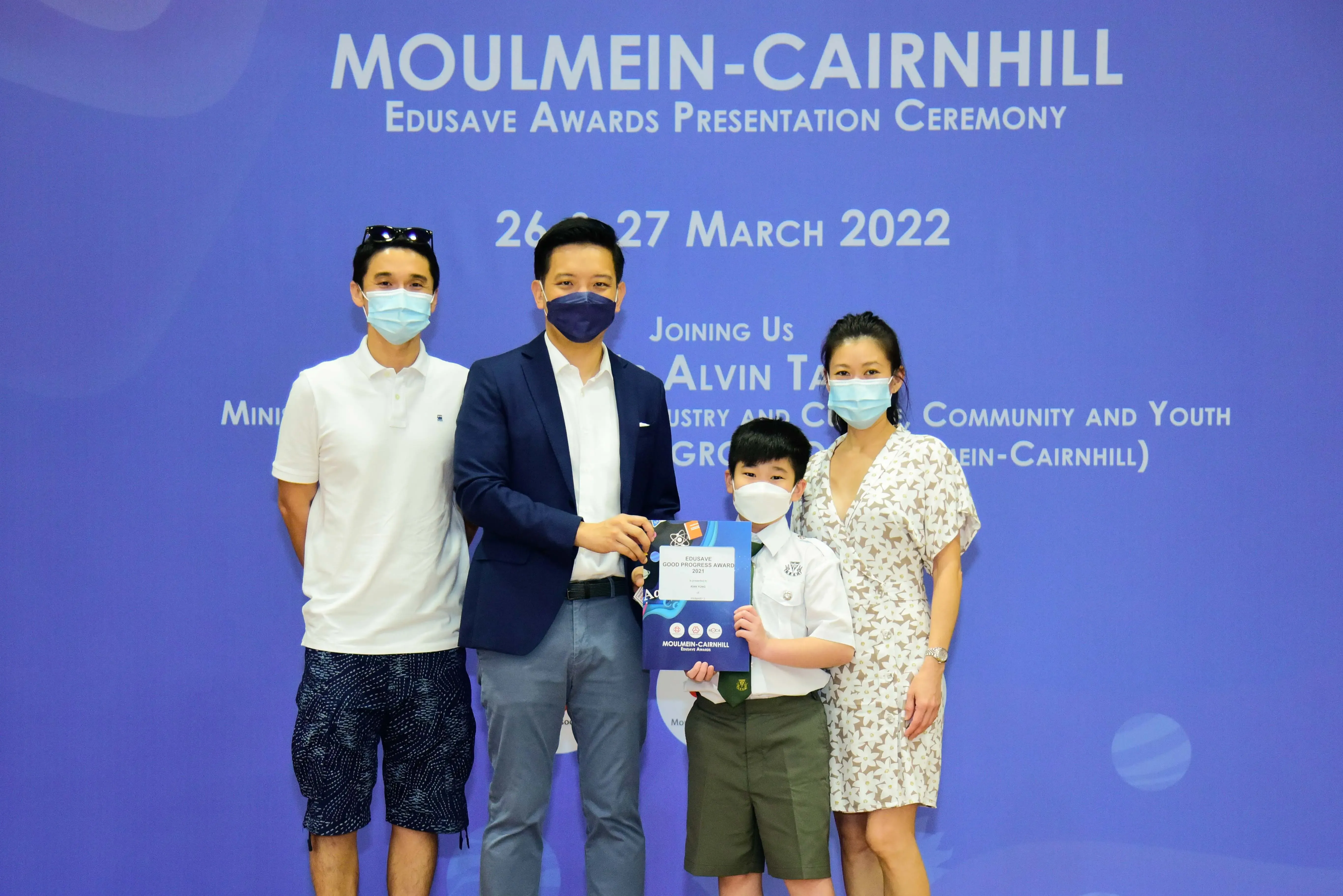 Four masked people pose at the Moulmein-Cairnhill Edusave Awards Presentation Ceremony on 26-27 March 2022.