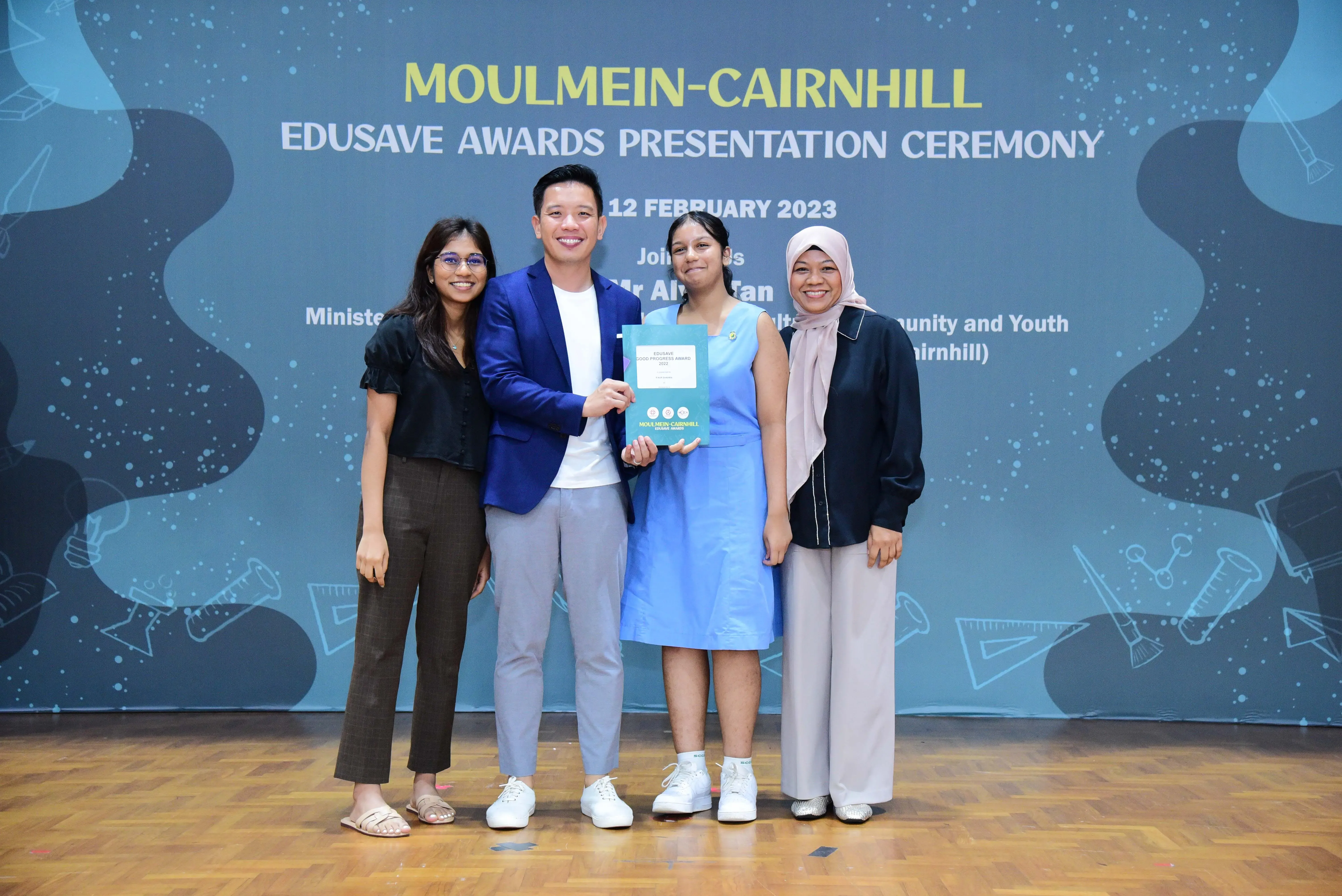 Four people smiling at the Moulmein-Cairnhill Edusave Awards Presentation Ceremony on 12 February 2023.