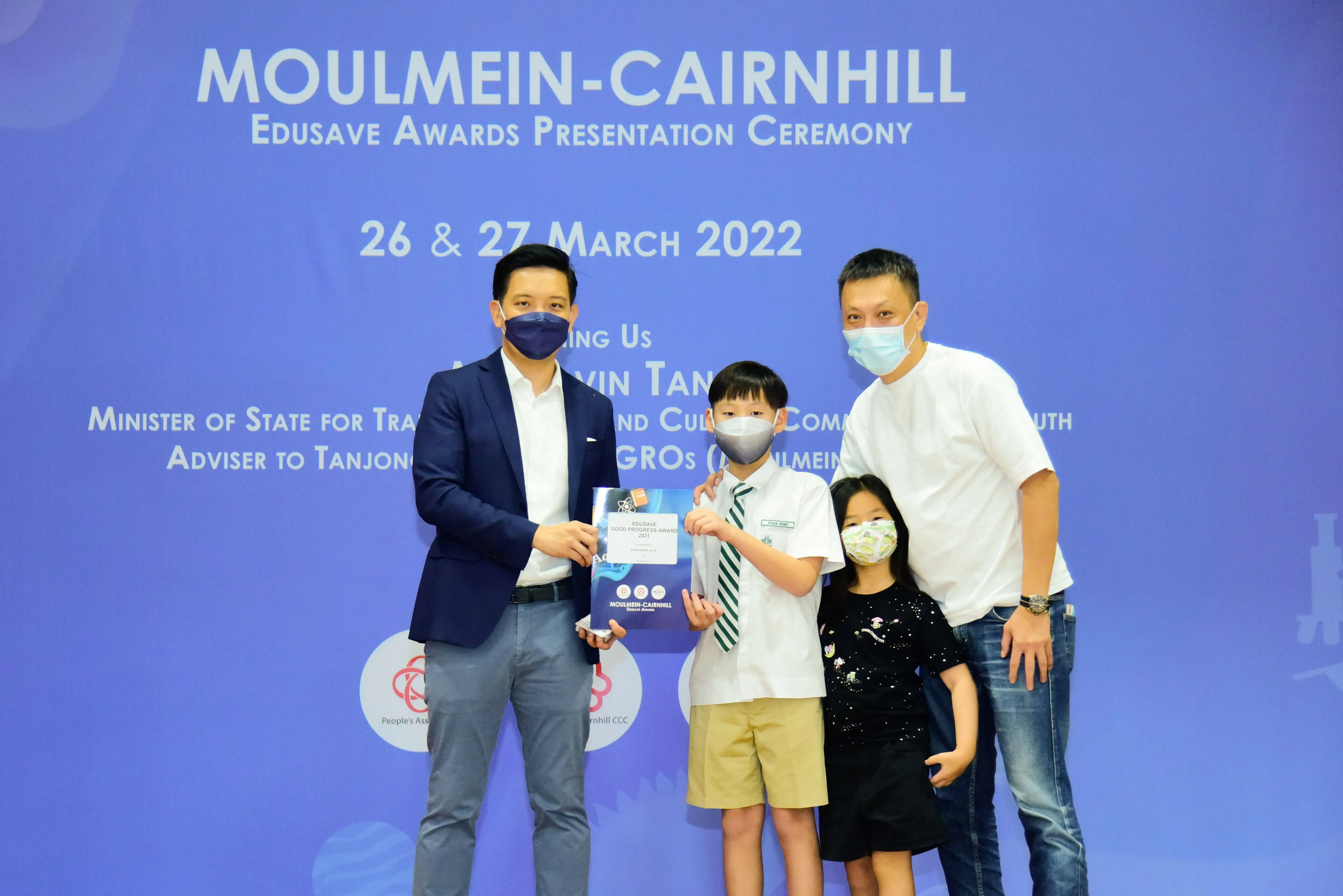 Four masked people pose at the Moulmein-Cairnhill Edusave Awards Presentation Ceremony on 26-27 March 2022.