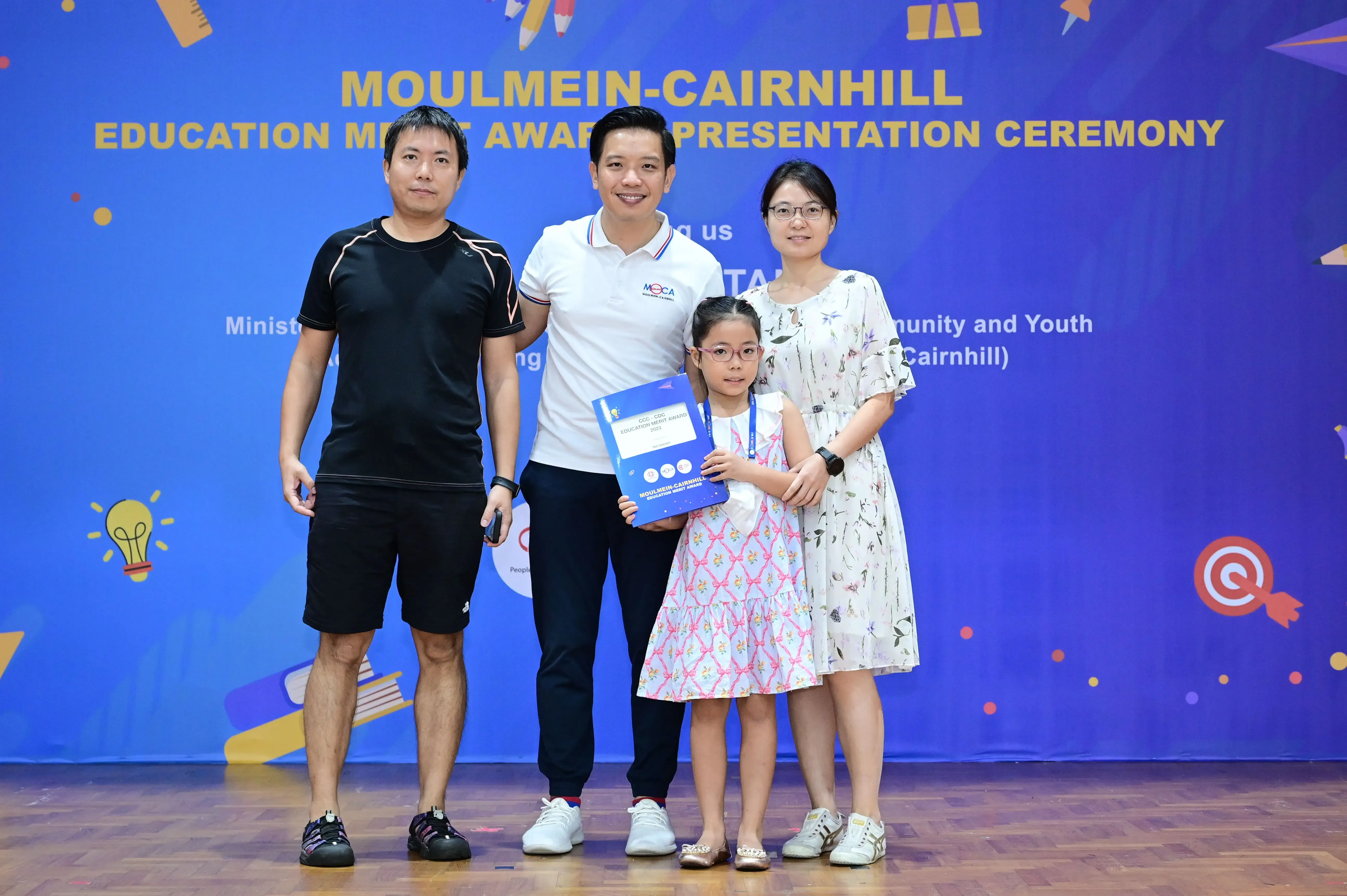 Three adults and a young girl pose at the Moulmein-Cairnhill Education Merit Award Presentation Ceremony.