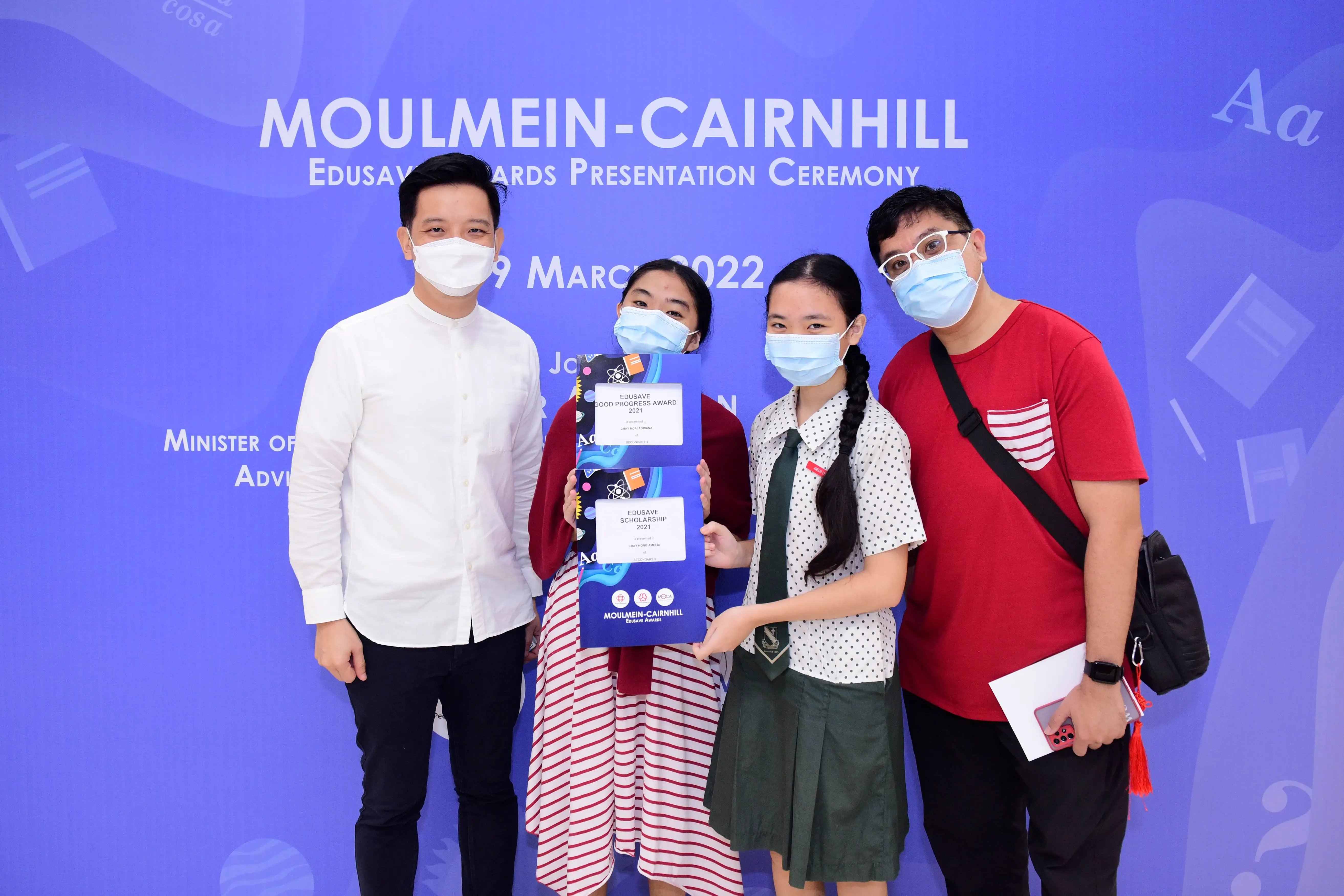Four masked people pose at the Moulmein-Cairnhill Edusave Awards Presentation Ceremony on 19 March 2022.