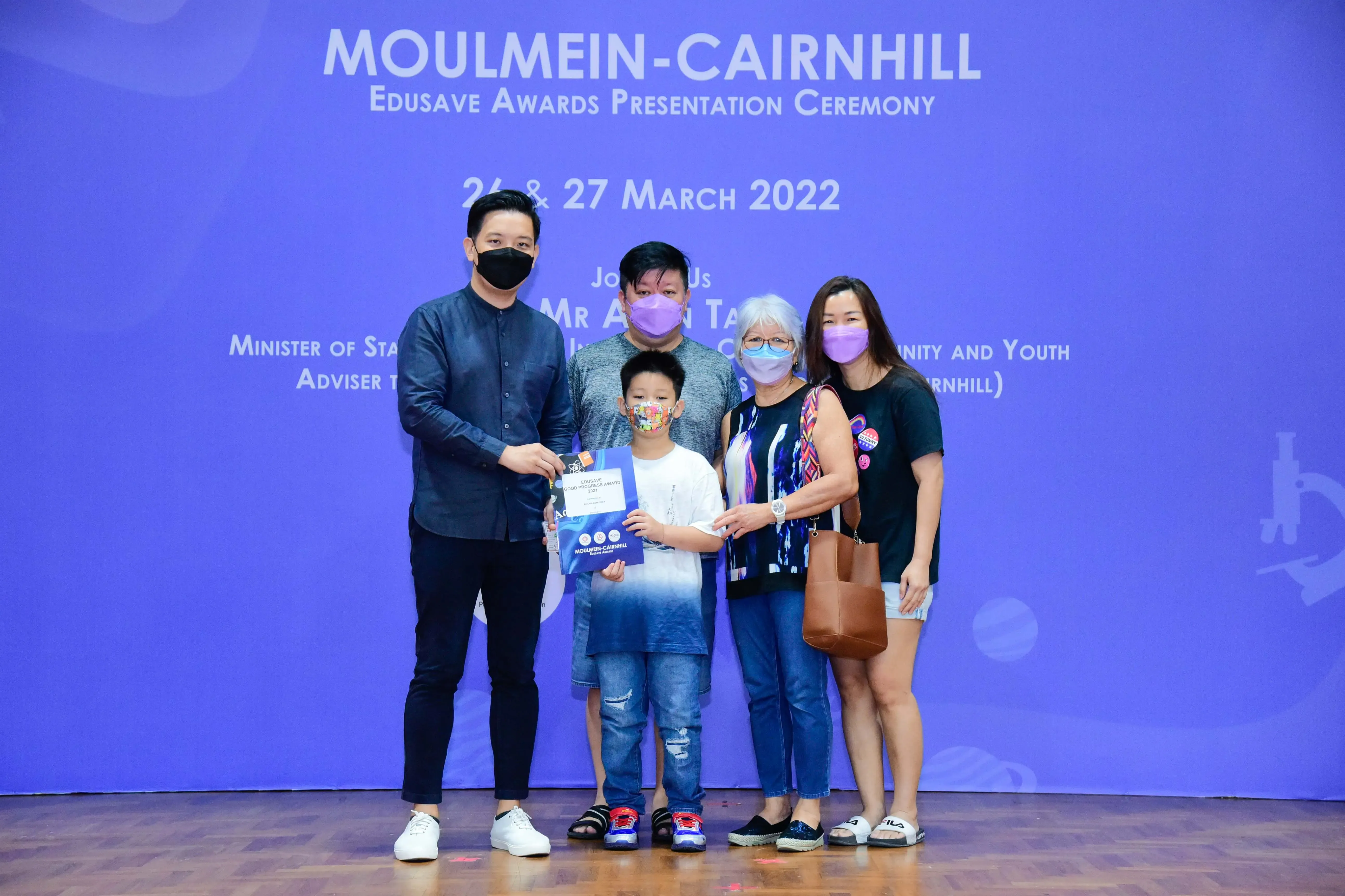 Five masked people pose at the Moulmein-Cairnhill Edusave Awards Ceremony on 26-27 March 2022.