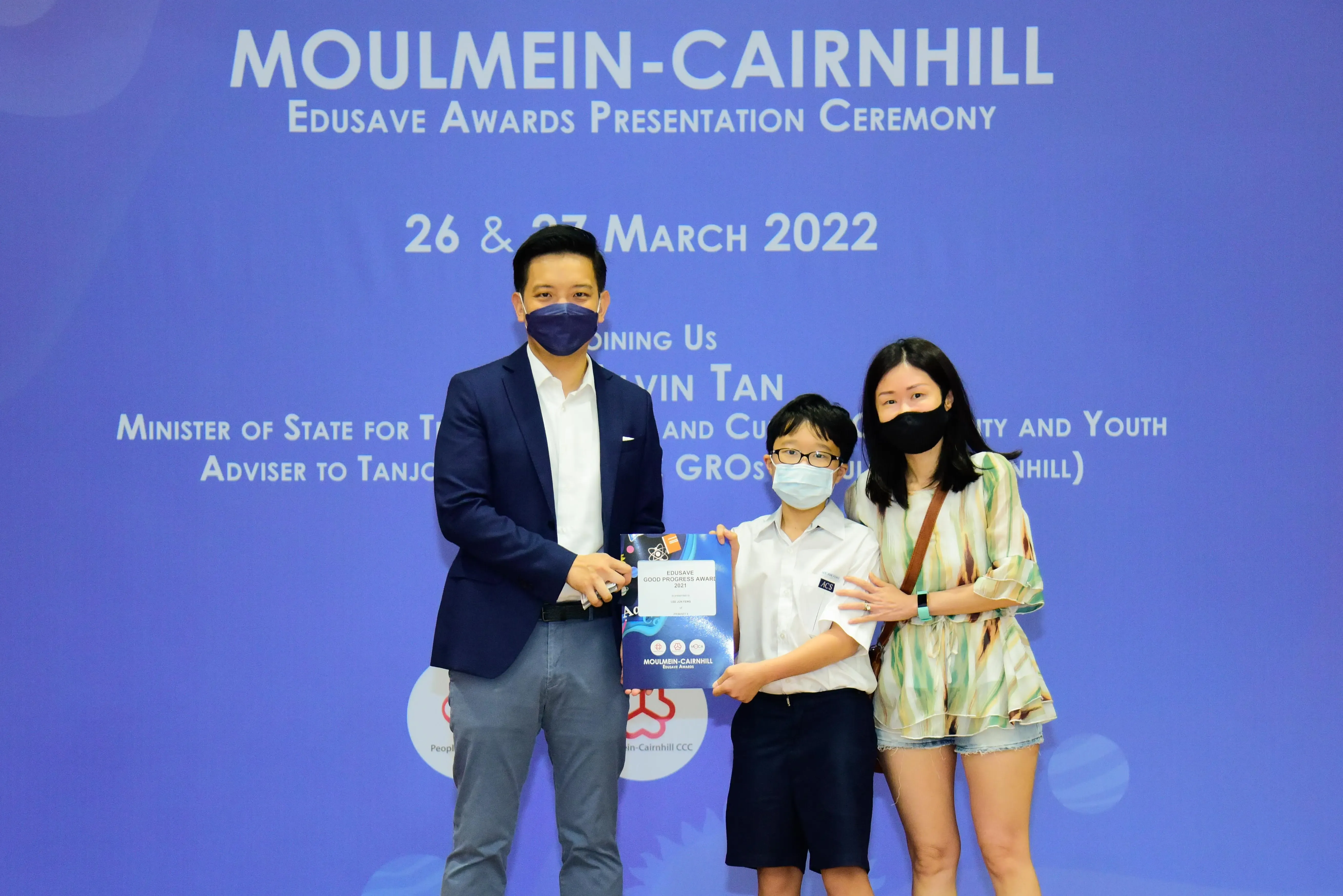 Three masked people pose at the Moulmein-Cairnhill Edusave Awards Presentation Ceremony on 26-27 March 2022.