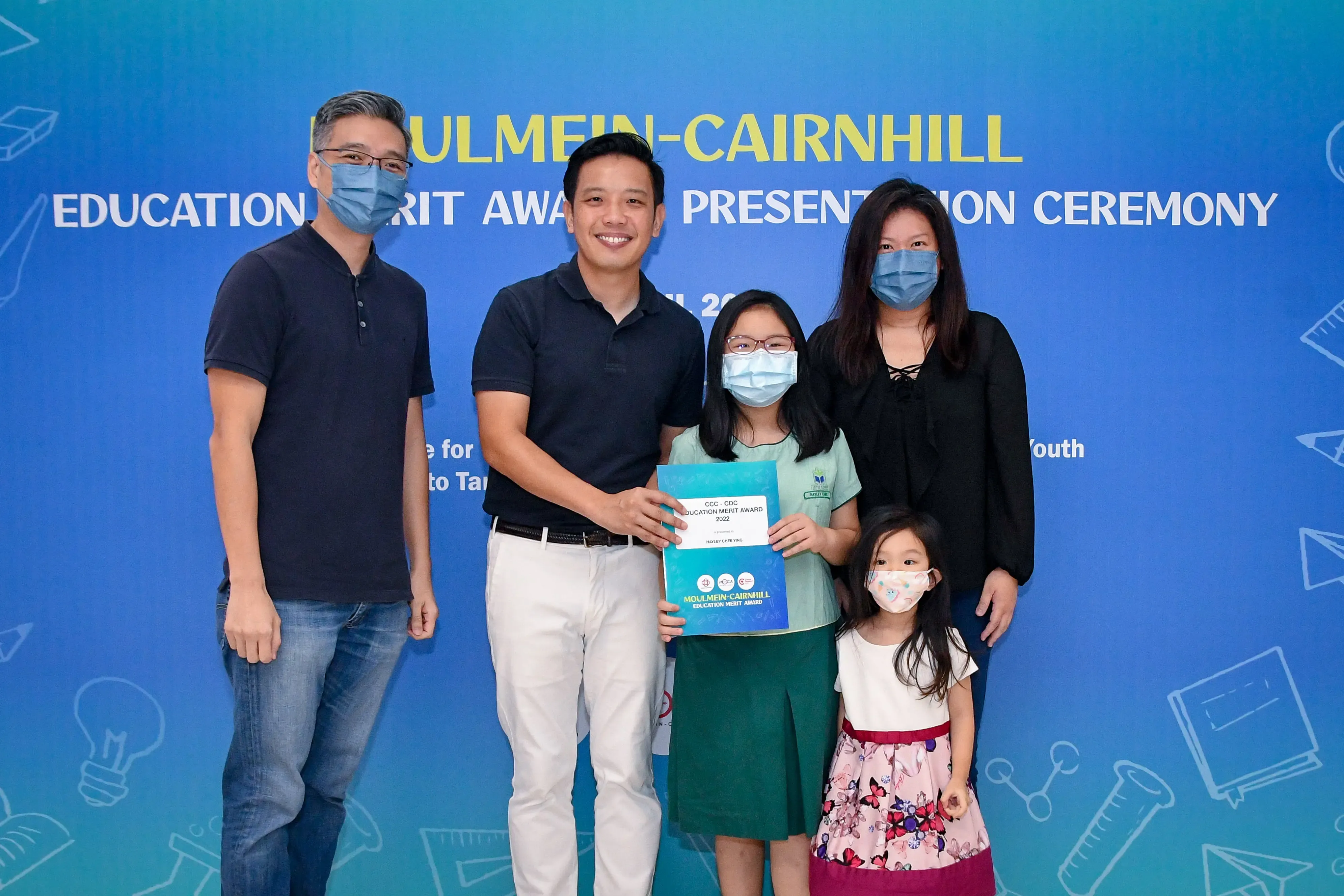 Five people pose at the Moulmein-Cairnhill Education Merit Award Presentation Ceremony, holding an award certificate.