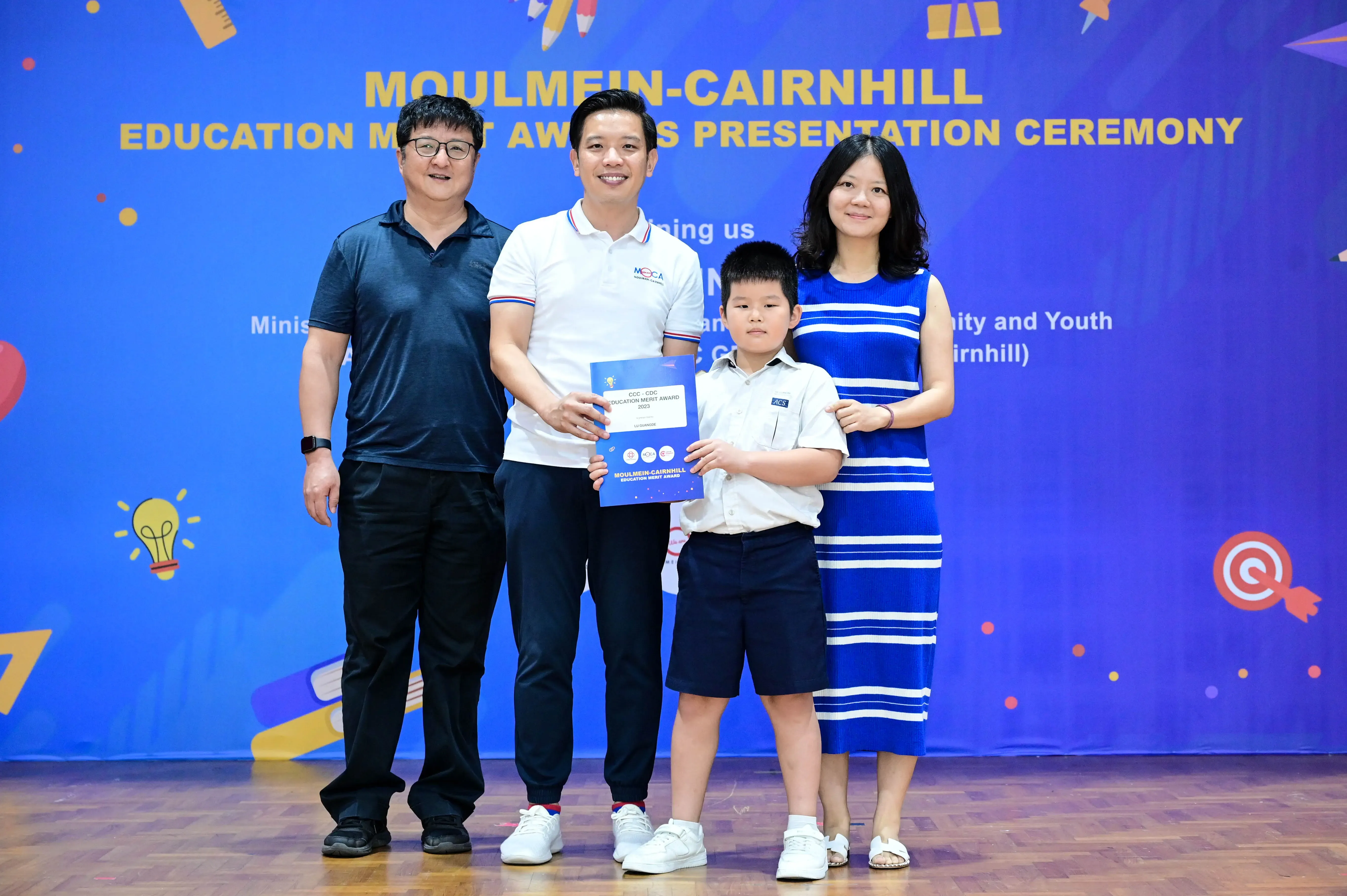 Four people pose with a certificate at the Moulmein-Cairnhill Education Merit Awards Presentation Ceremony.