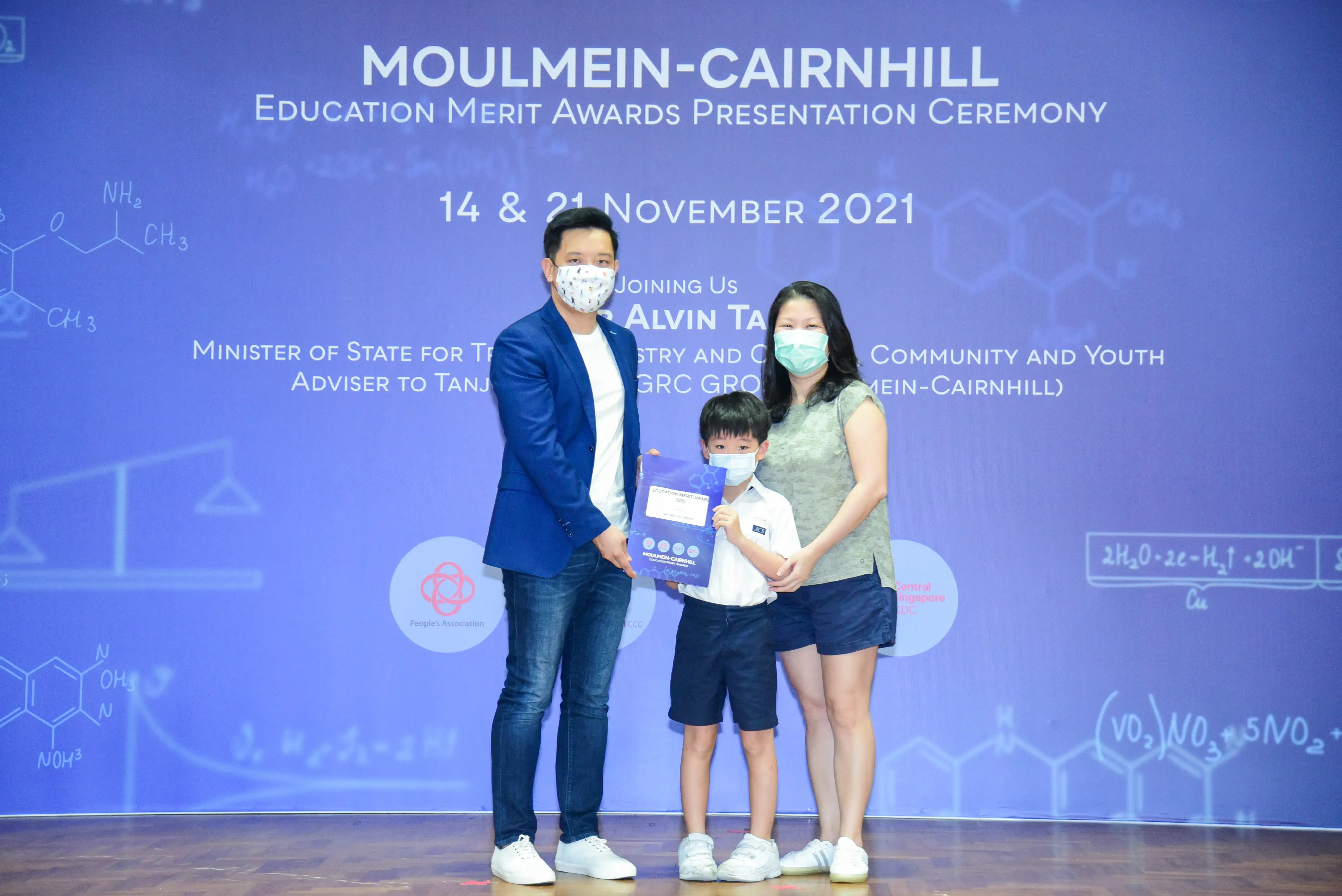 Three masked people pose at the Moulmein-Cairnhill Education Merit Awards Ceremony on November 2021.
