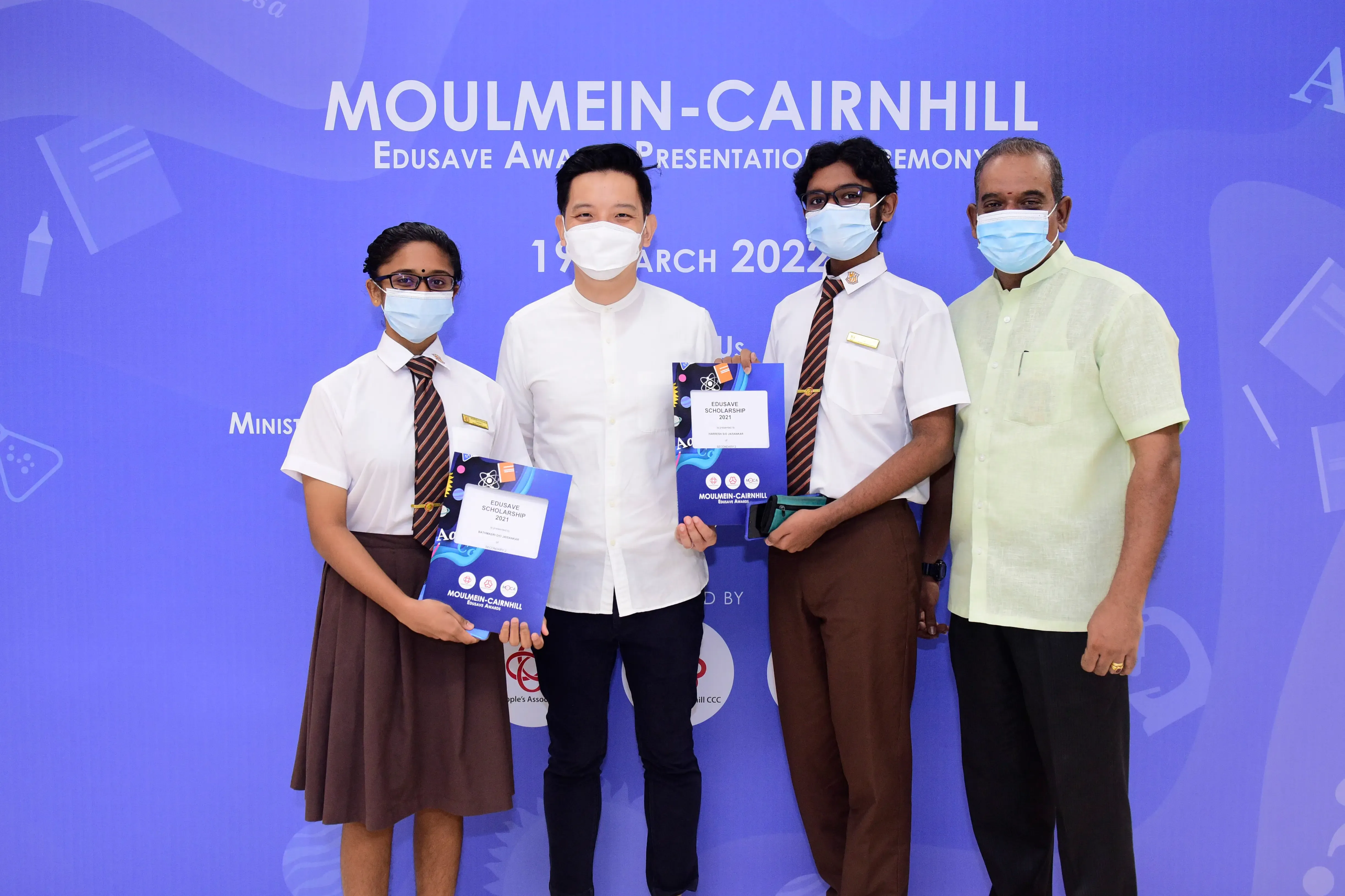 Four masked people pose at the Moulmein-Cairnhill Edusave Award Presentation Ceremony on 19 March 2022.