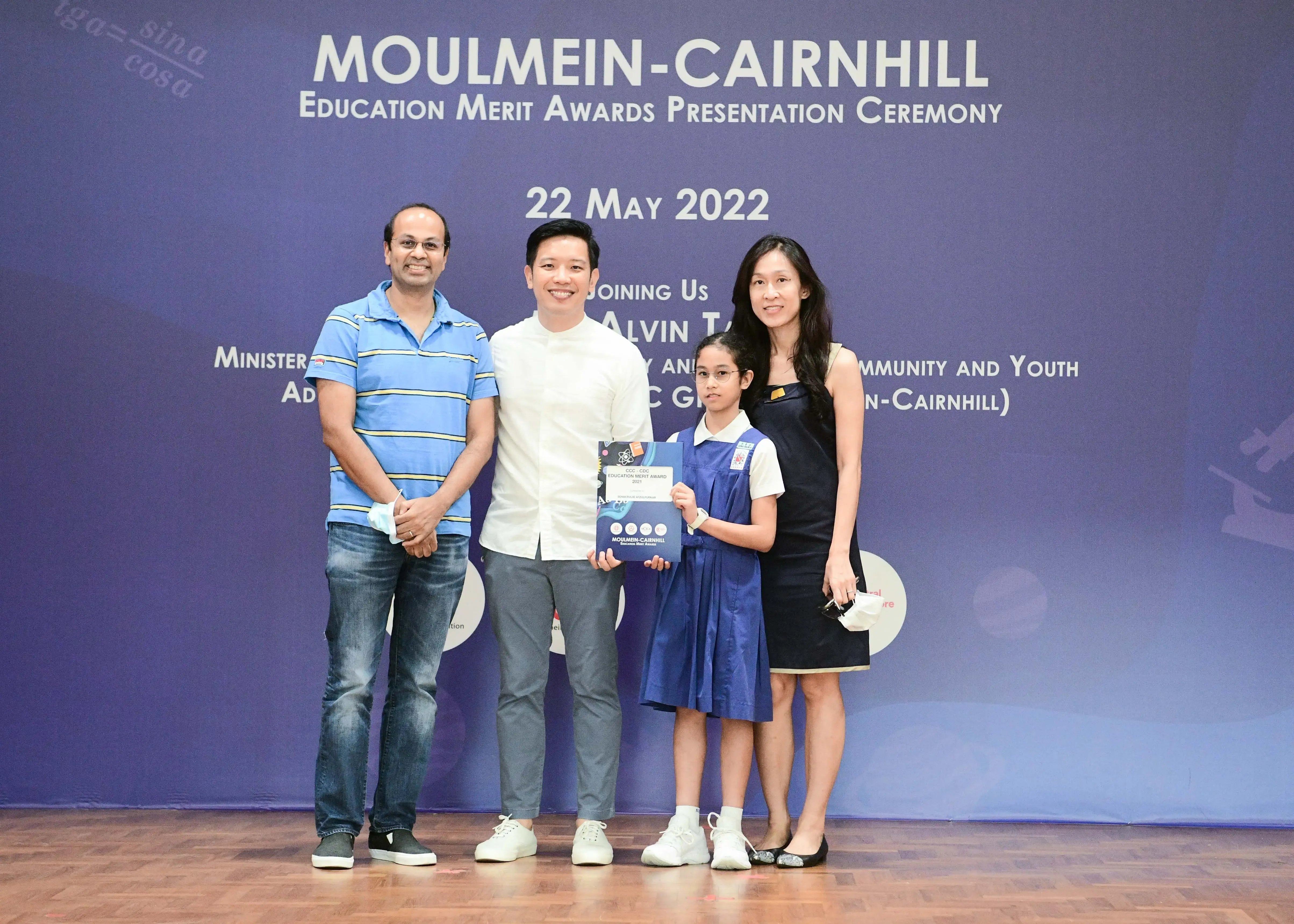 Four people pose on a stage at the Moulmein-Cairnhill Education Merit Awards Ceremony on 22 May 2022.