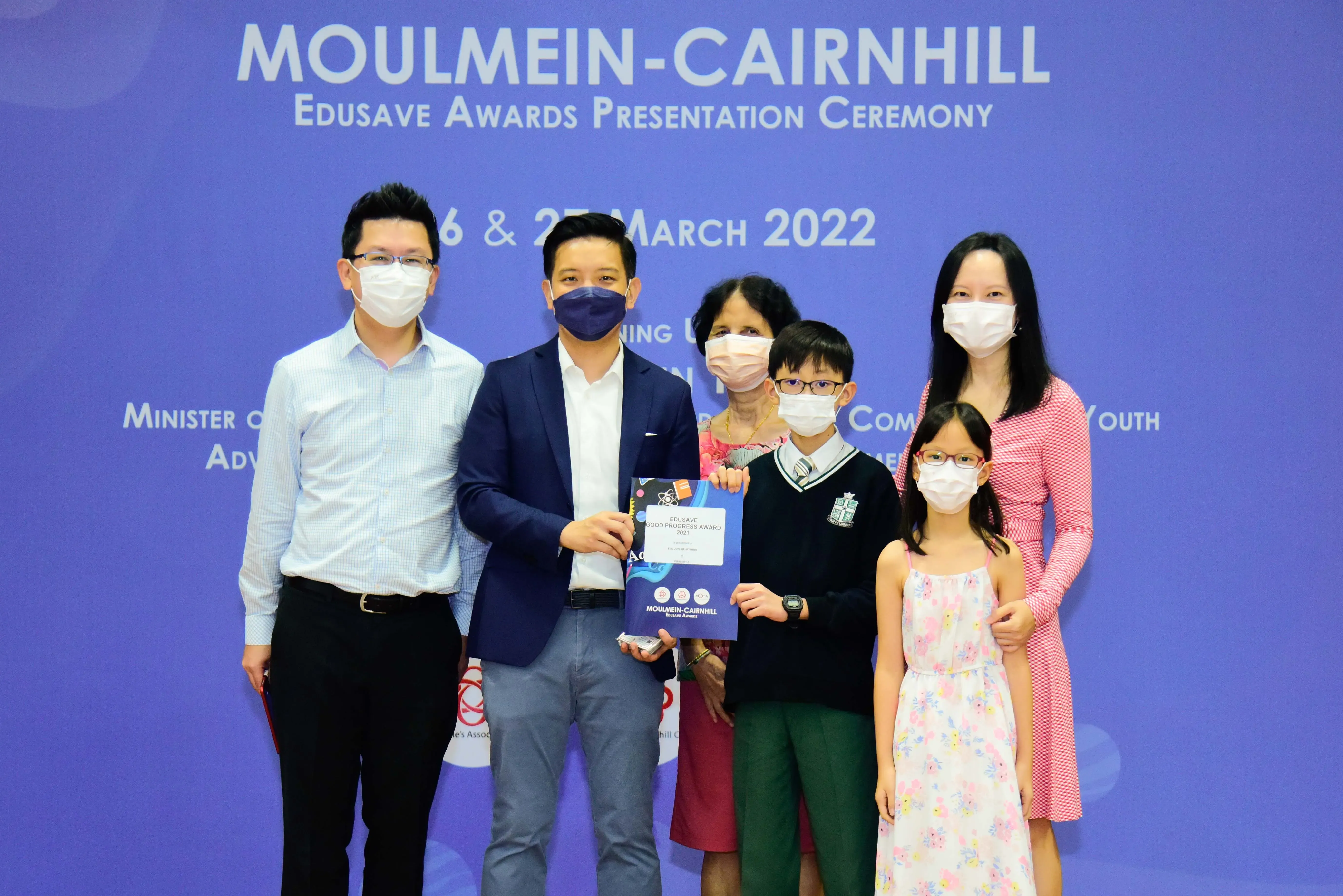 Six masked people pose at the Moulmein-Cairnhill Edusave Awards Presentation Ceremony on March 2022.