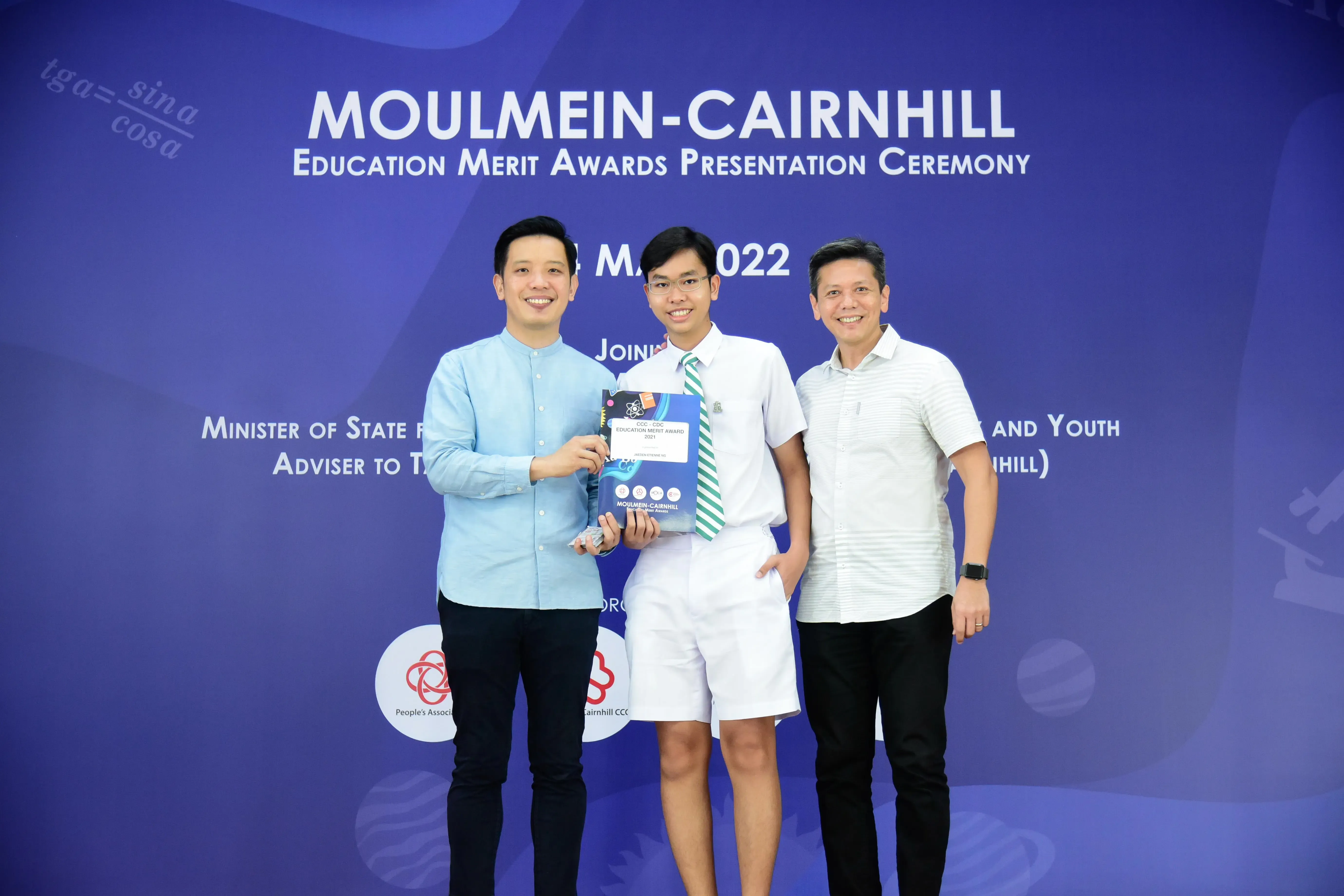 Three smiling men pose at the Moulmein-Cairnhill Education Merit Awards Presentation Ceremony in 2022.