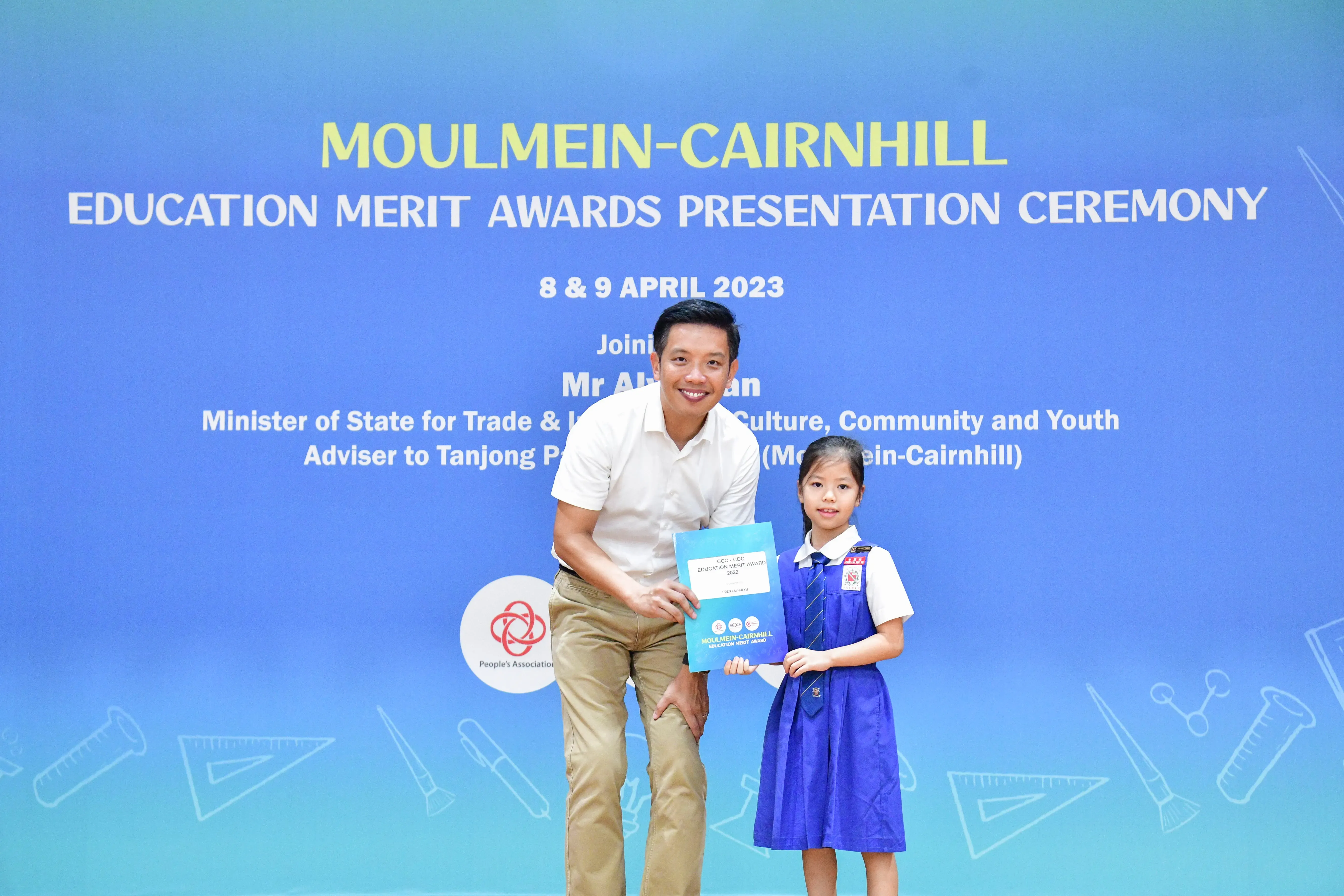 Man and young girl in school uniform hold an award certificate at Moulmein-Cairnhill Education Merit Awards April 2023.