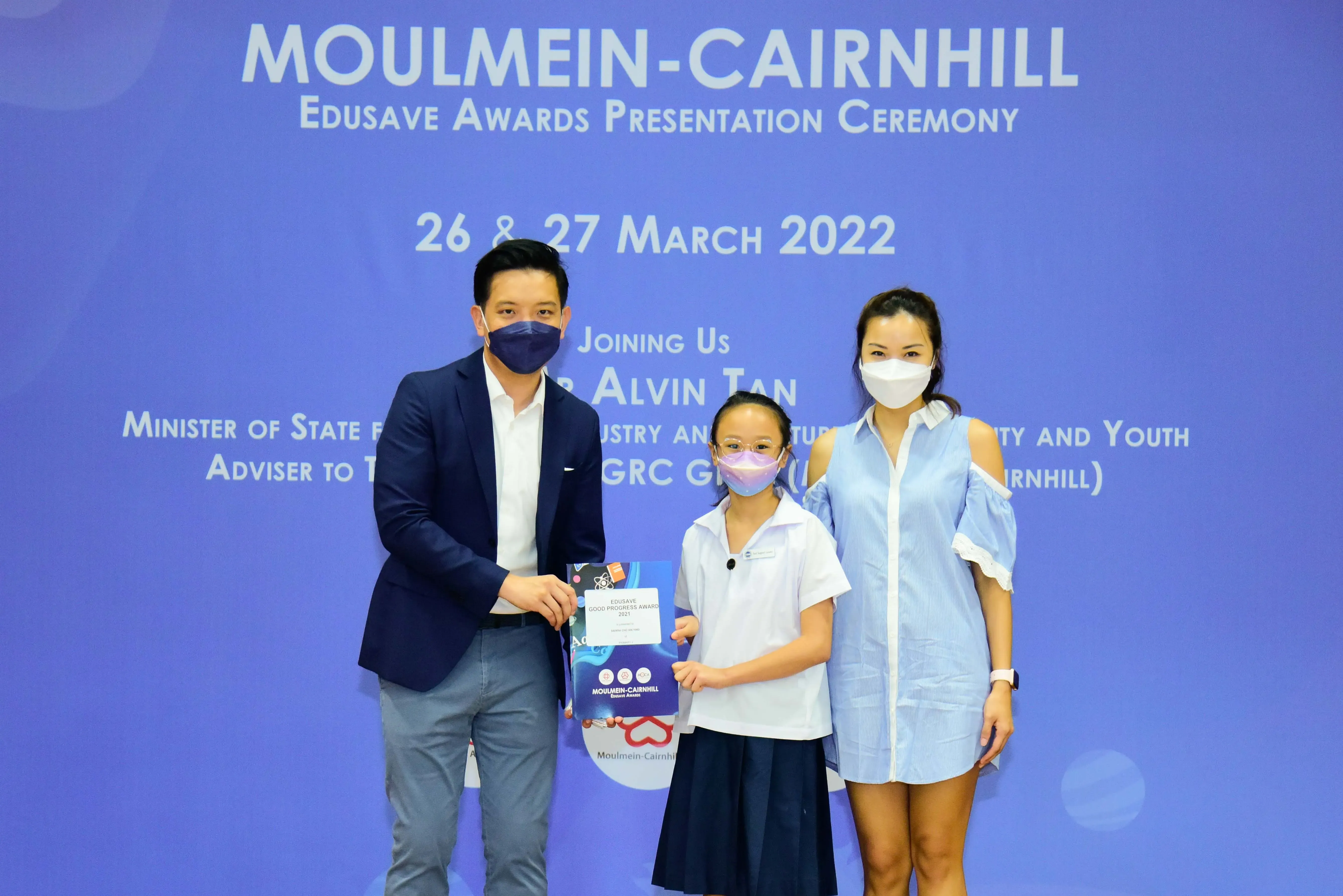 Three masked people pose at the Moulmein-Cairnhill Edusave Awards Presentation Ceremony on March 26-27, 2022.