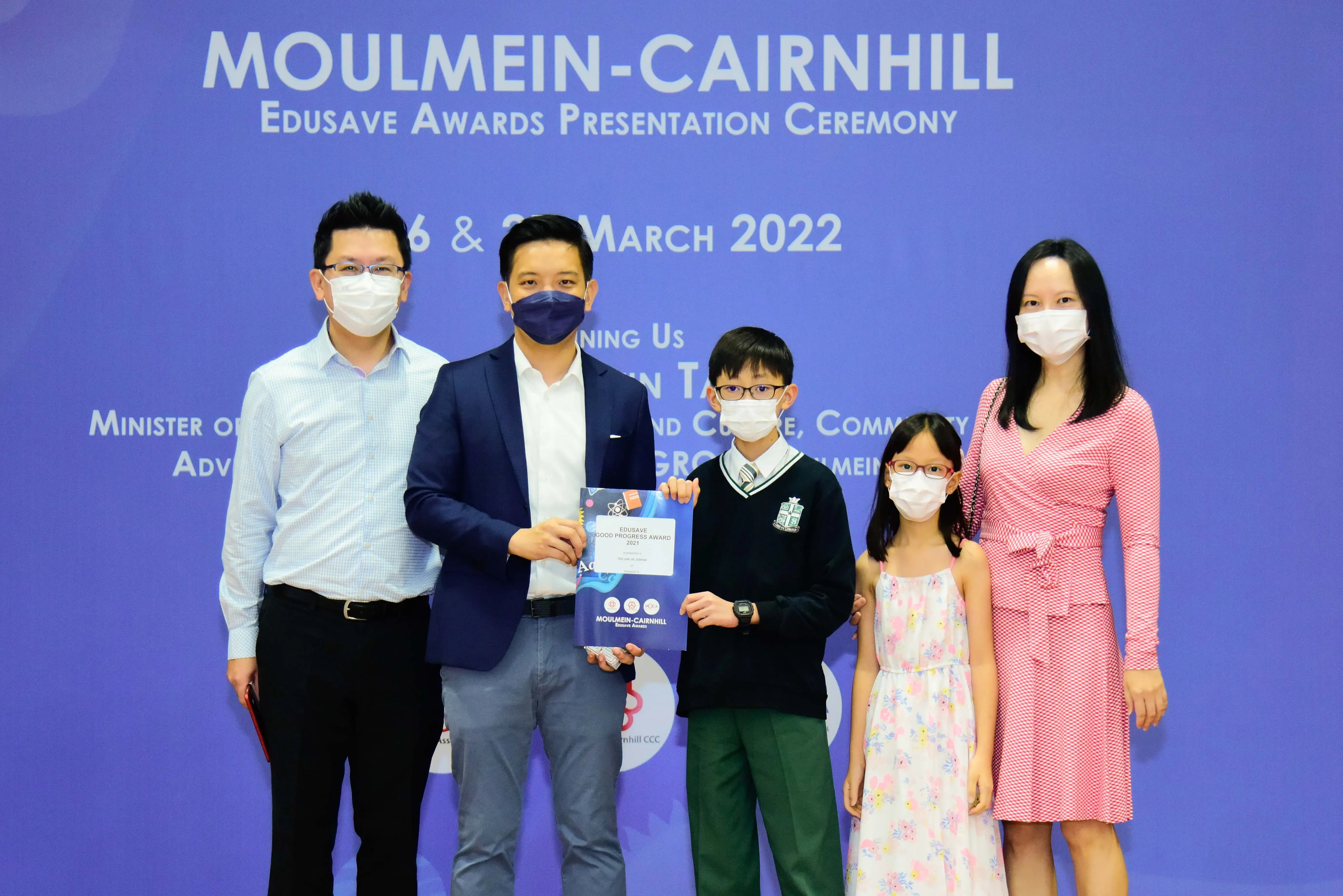 Five masked people pose at the Moulmein-Cairnhill Edusave Awards Presentation Ceremony in March 2022.