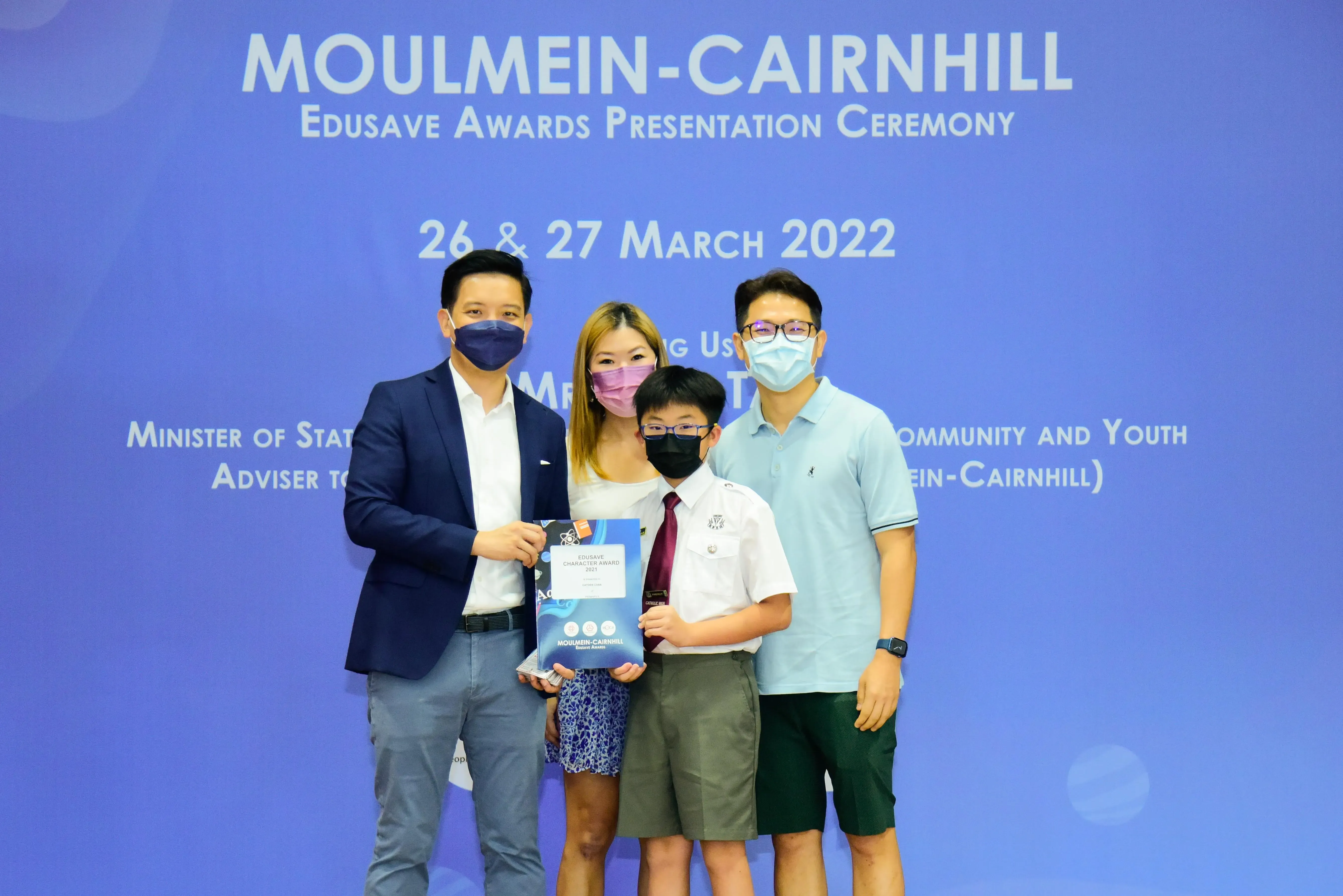 Four masked people pose at the Moulmein-Cairnhill Edusave Awards Presentation Ceremony on 26-27 March 2022.