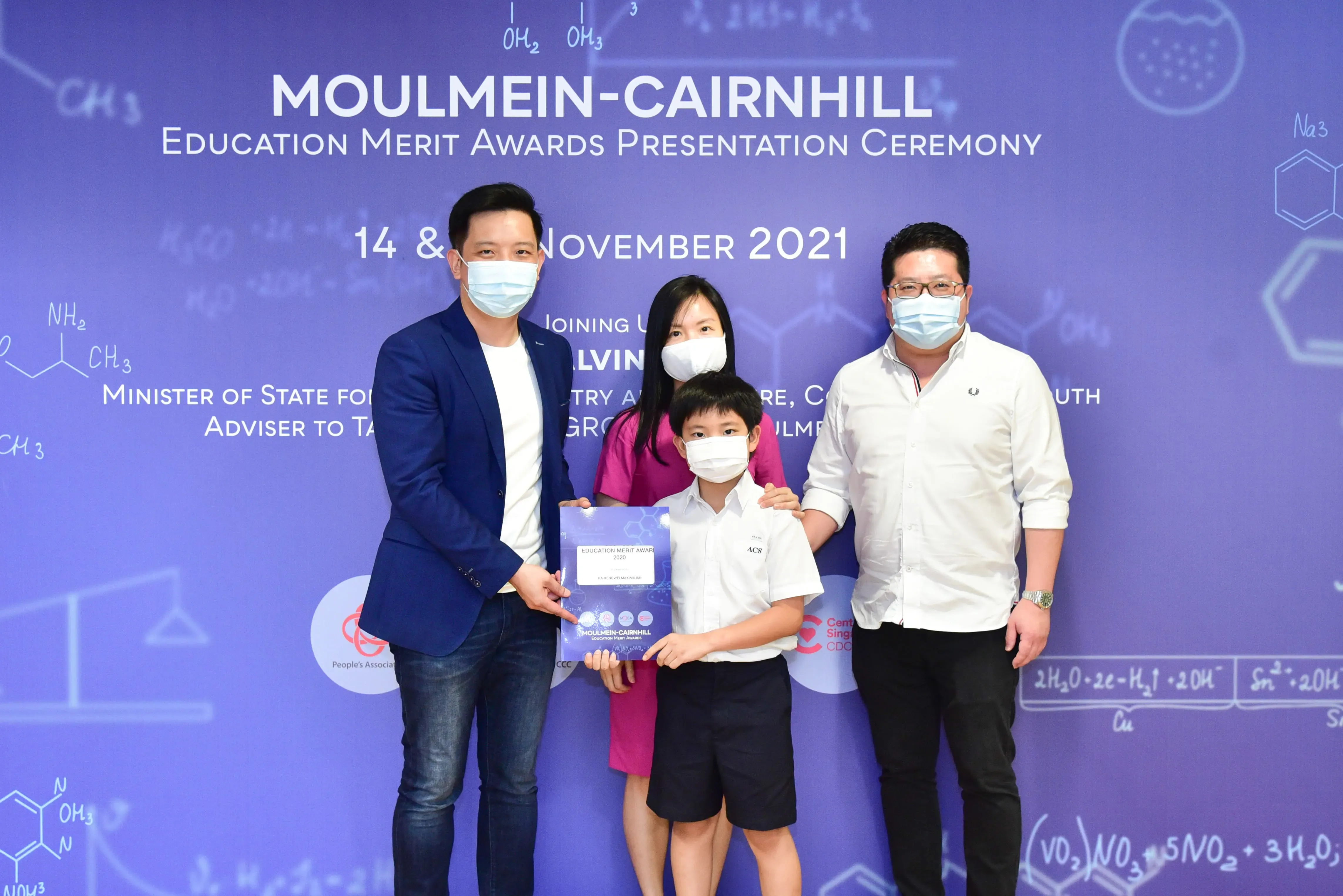 Four masked people pose at the Moulmein-Cairnhill Education Merit Awards Presentation Ceremony, November 2021.
