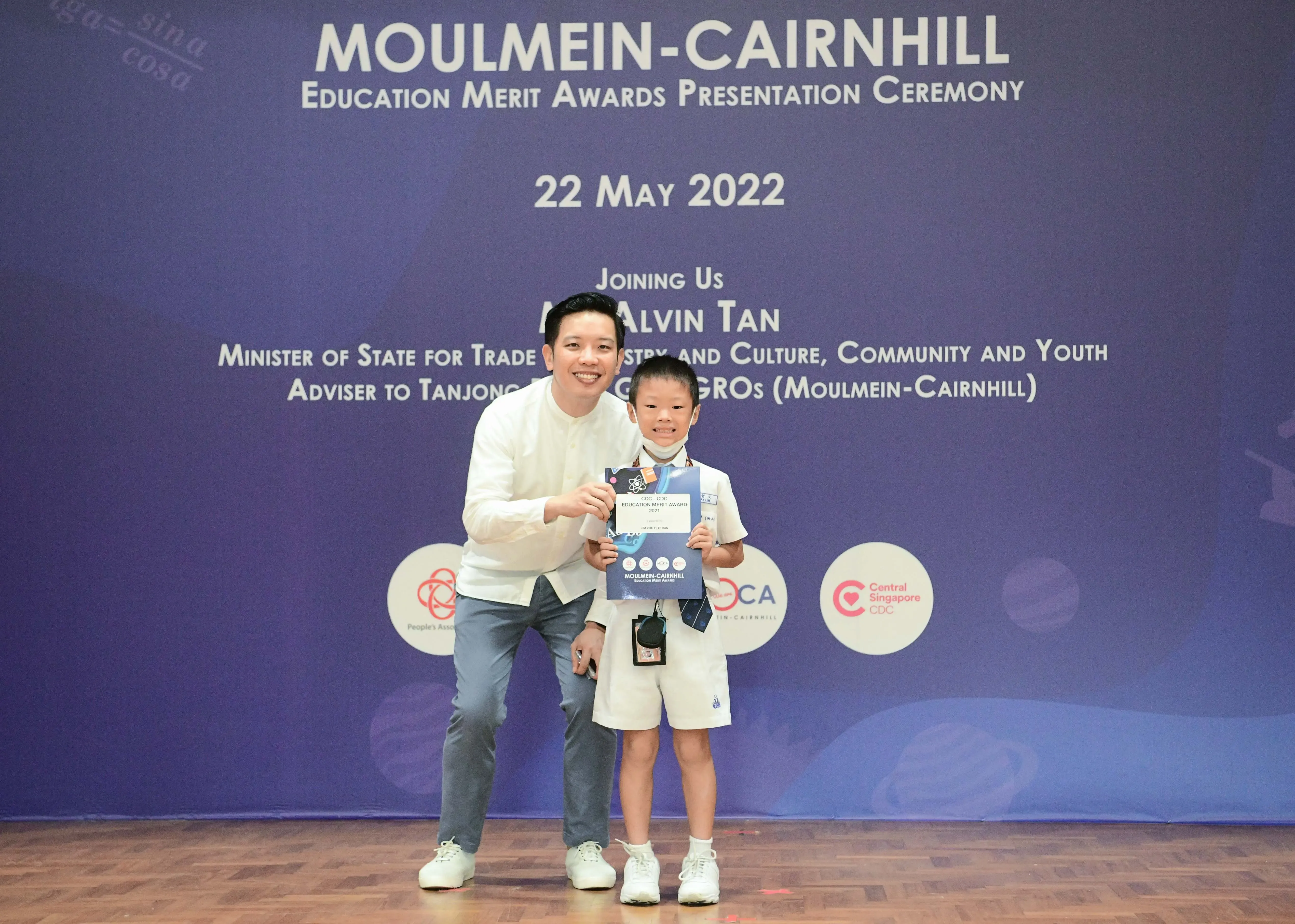 A man and a young student pose holding an award certificate at the Moulmein-Cairnhill Education Merit Awards on 22 May 2022.