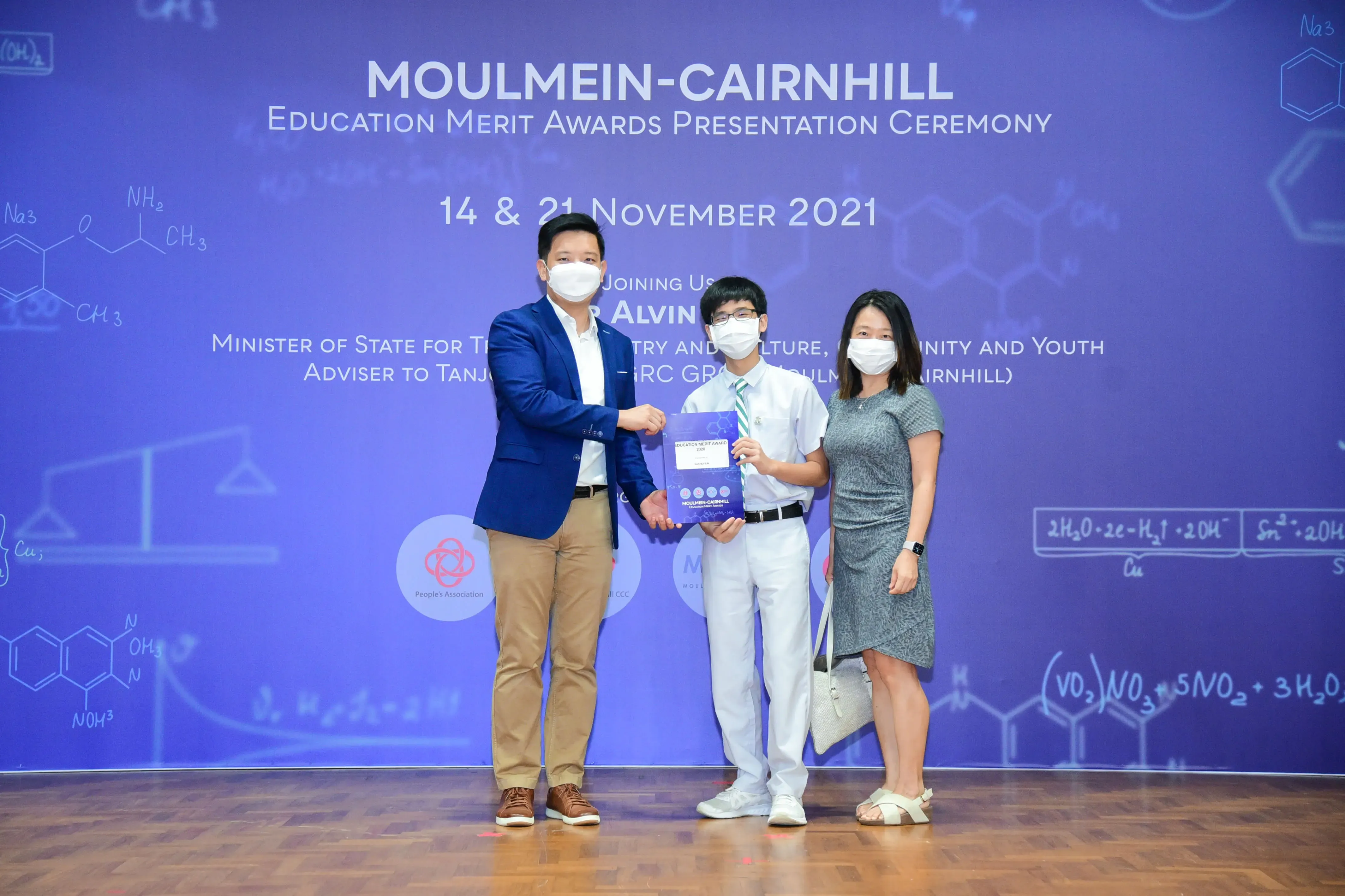 Three masked people pose at the Moulmein-Cairnhill Education Merit Awards Presentation Ceremony, November 2021.