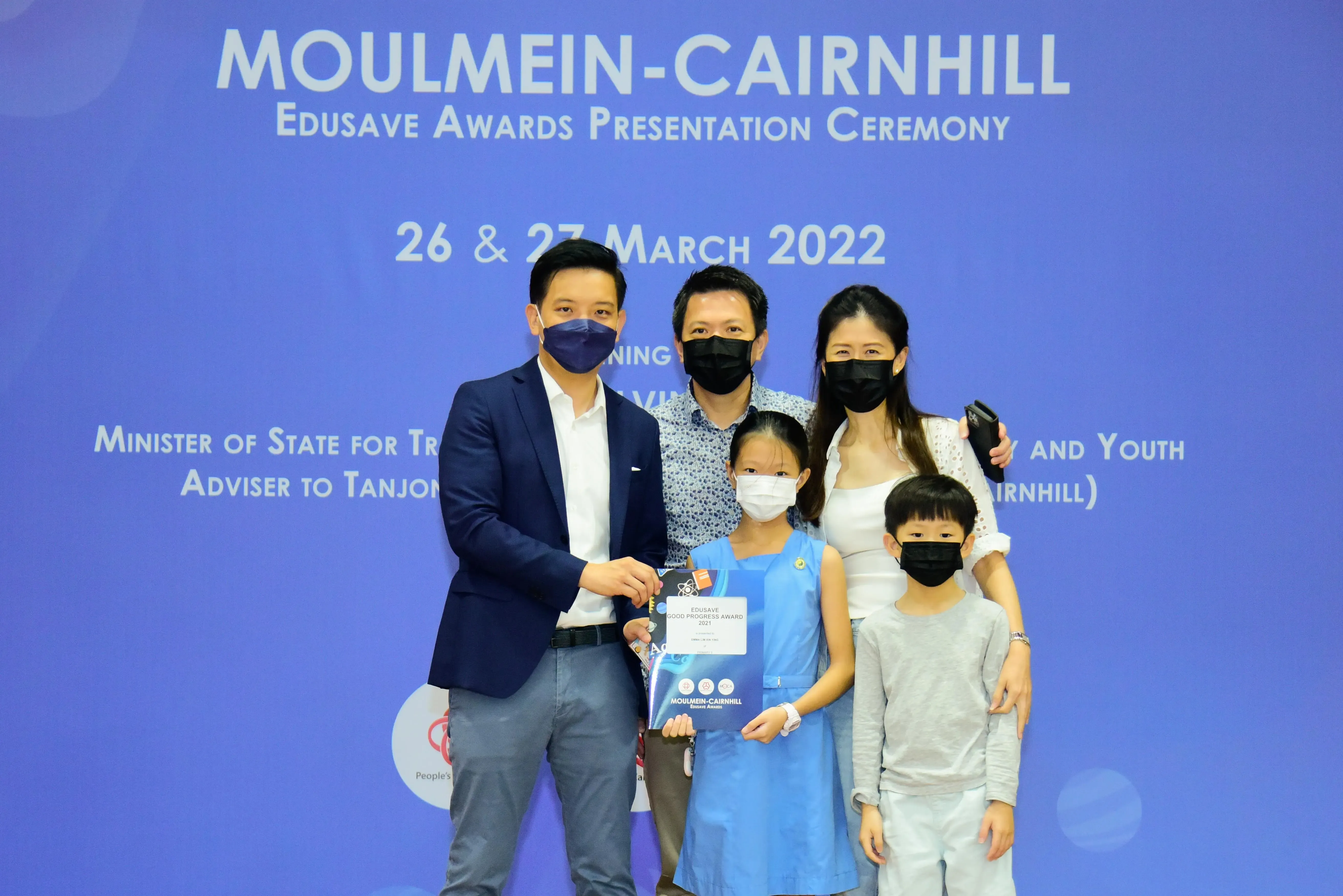 Five masked people pose at the Moulmein-Cairnhill Edusave Awards Presentation Ceremony on 26-27 March 2022.