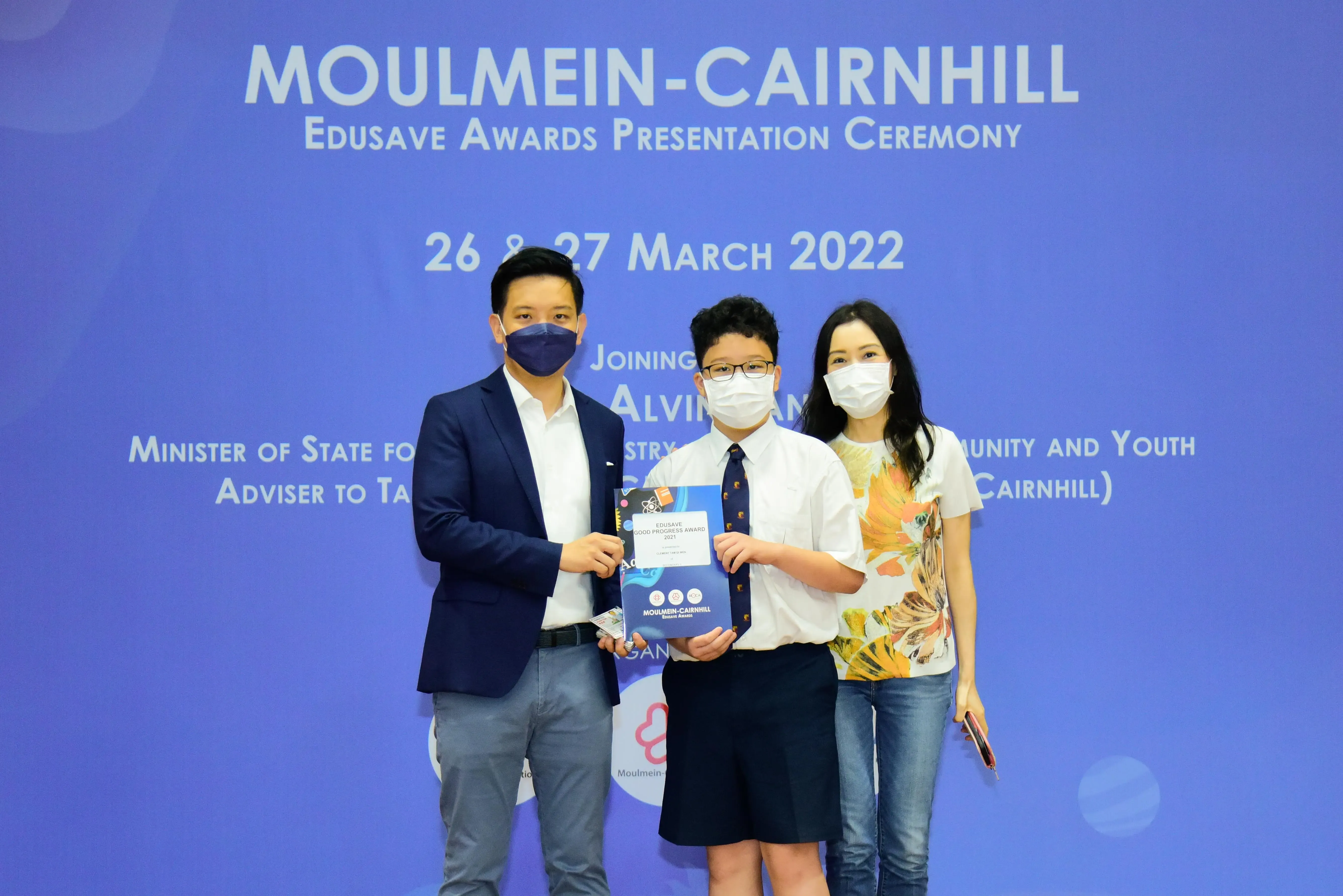 Three masked people pose at the Moulmein-Cairnhill Edusave Awards Presentation Ceremony on 26-27 March 2022.