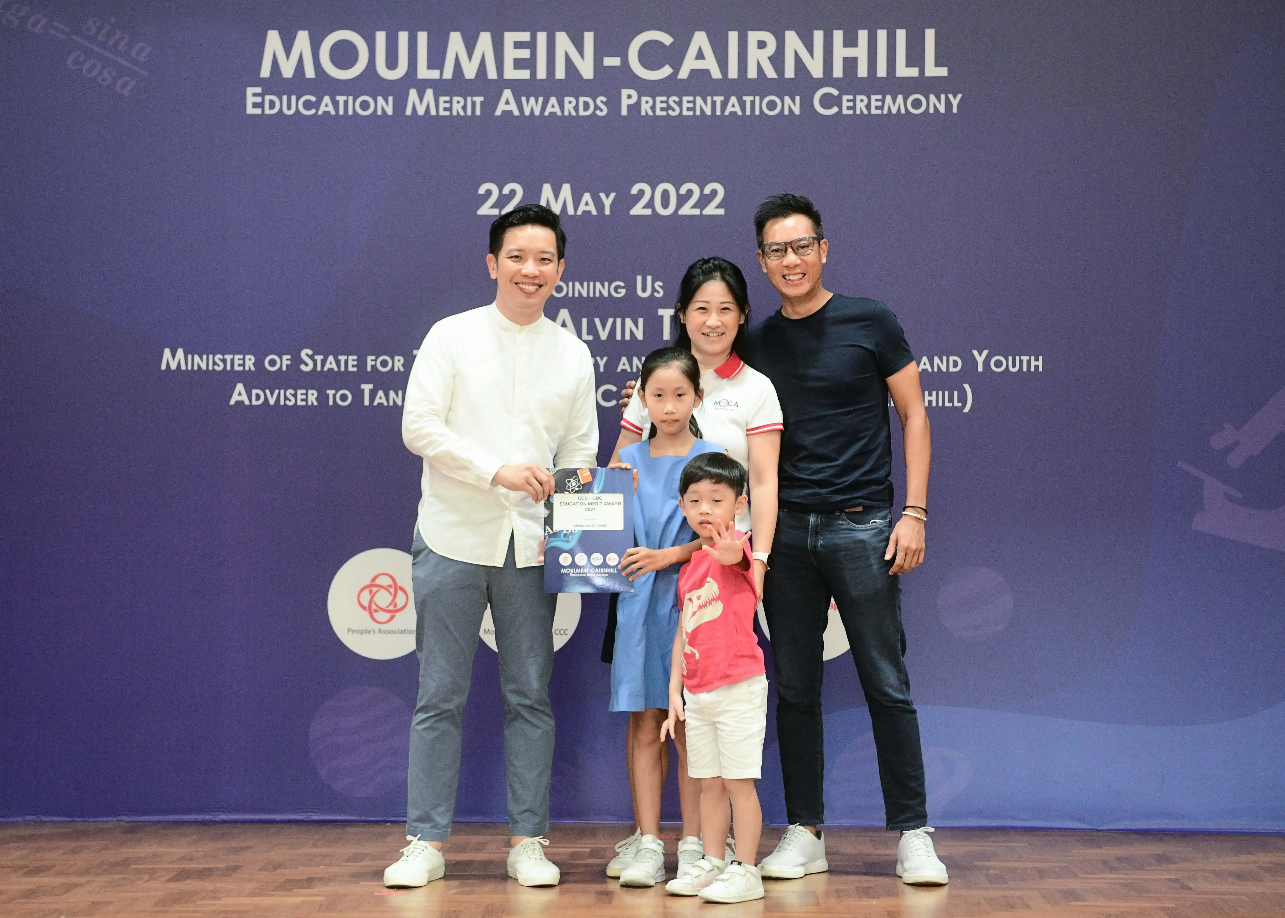 Five people pose with an award certificate at the Moulmein-Cairnhill Education Merit Awards Ceremony on 22 May 2022.