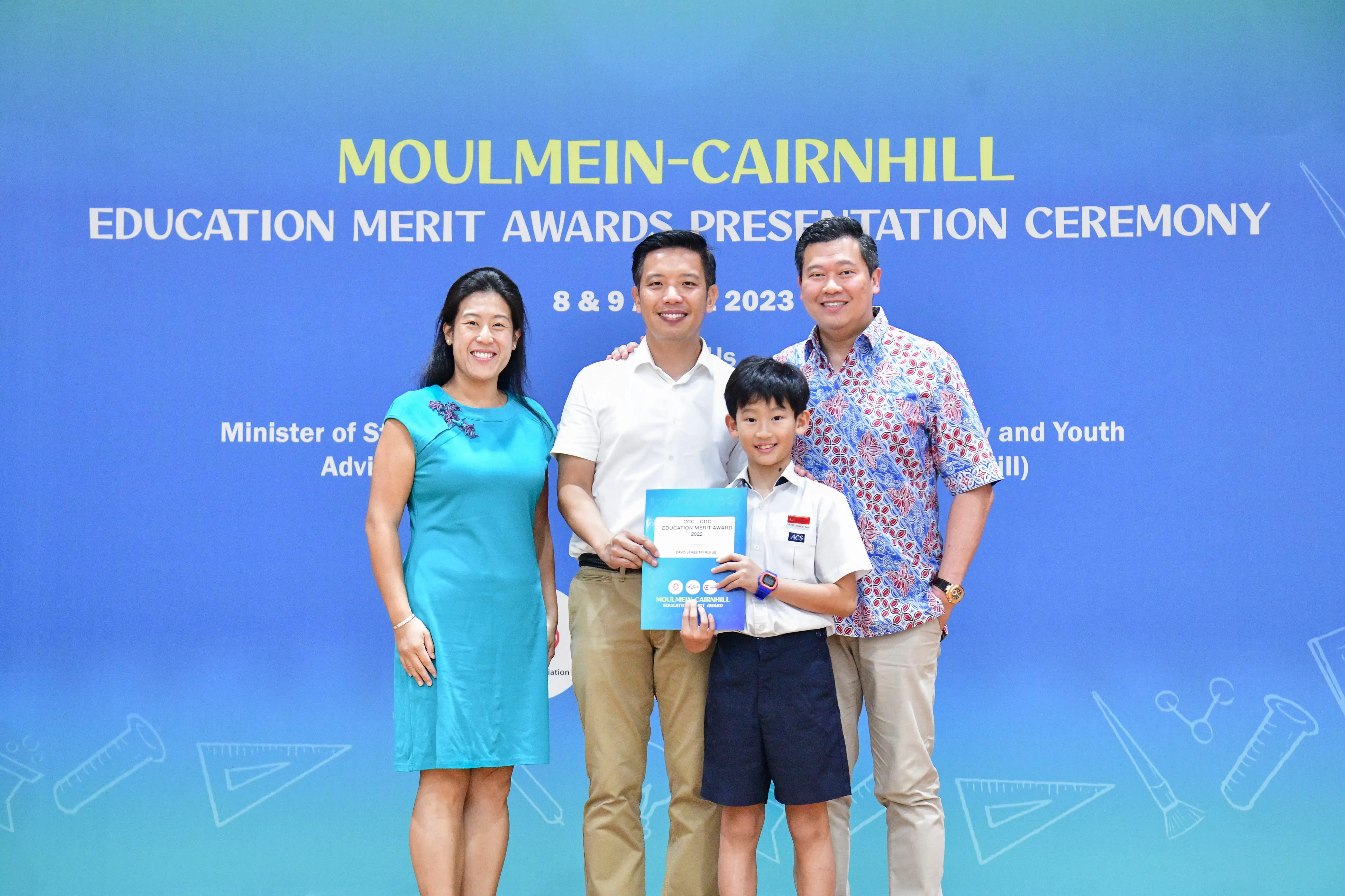Three adults and a boy holding an award certificate pose at the Moulmein-Cairnhill Education Merit Awards 2023.