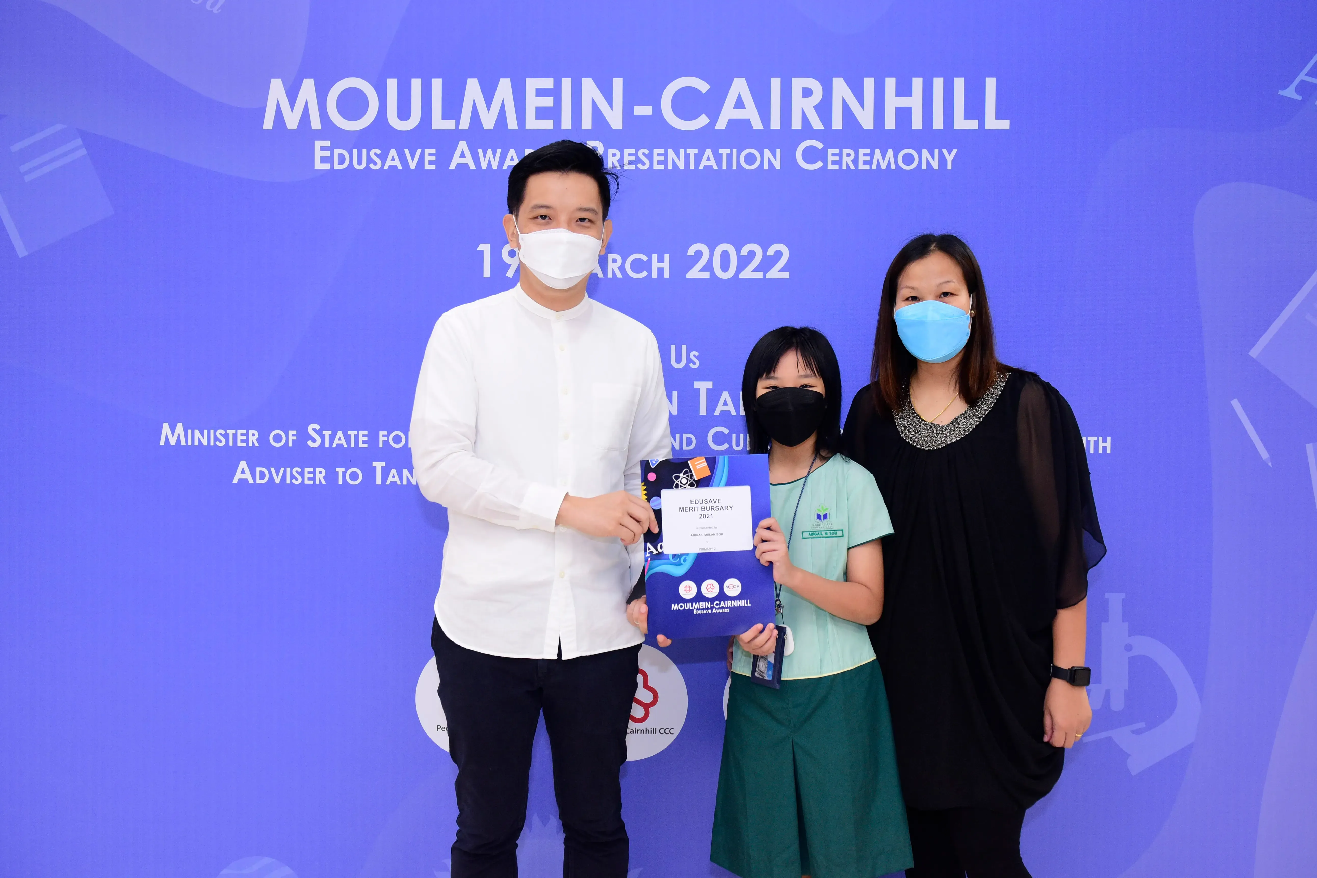 Three masked people pose at the Moulmein-Cairnhill Edusave Award Presentation Ceremony on 19 March 2022.