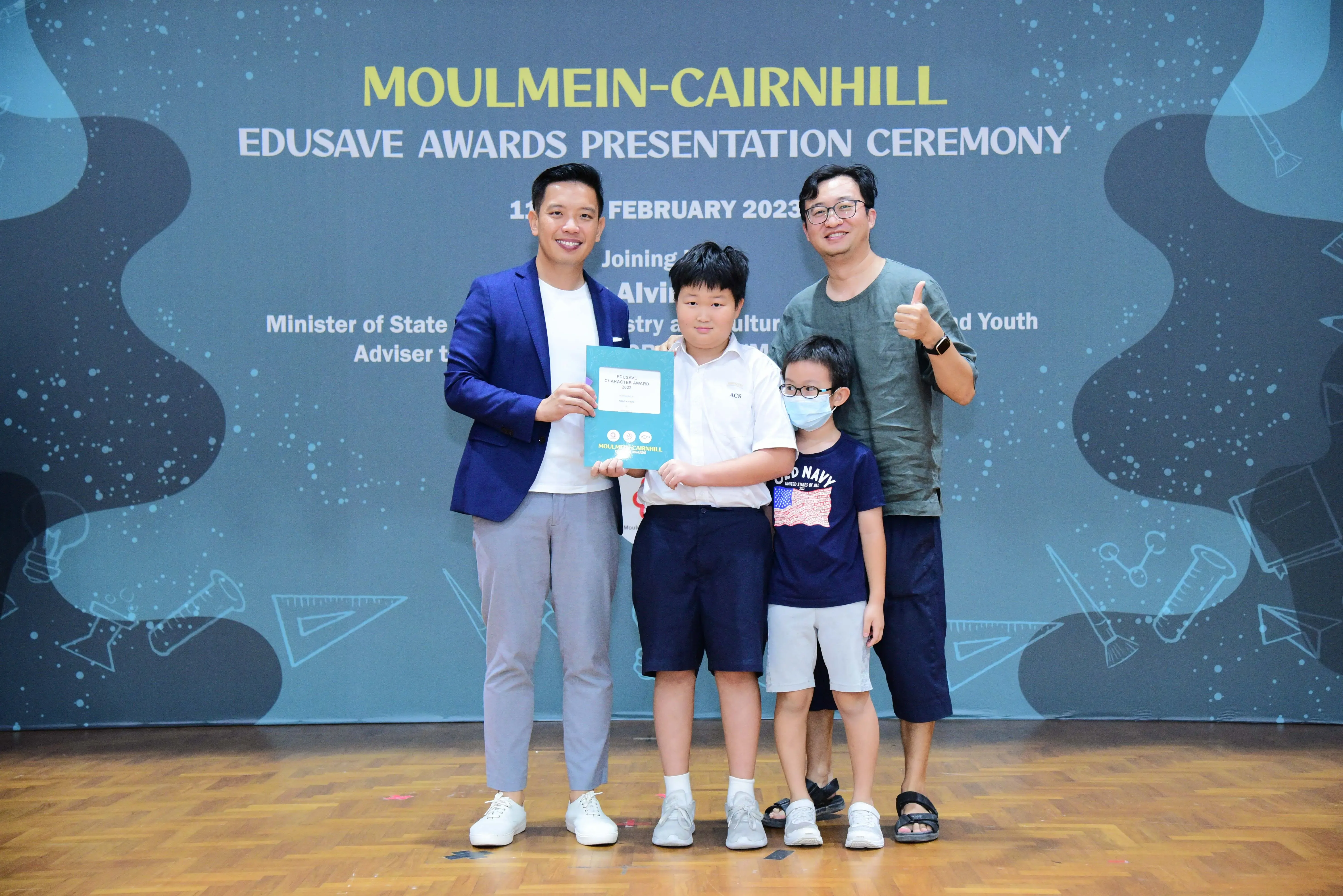 Four people pose at the Moulmein-Cairnhill Edusave Awards Presentation Ceremony in February 2023.
