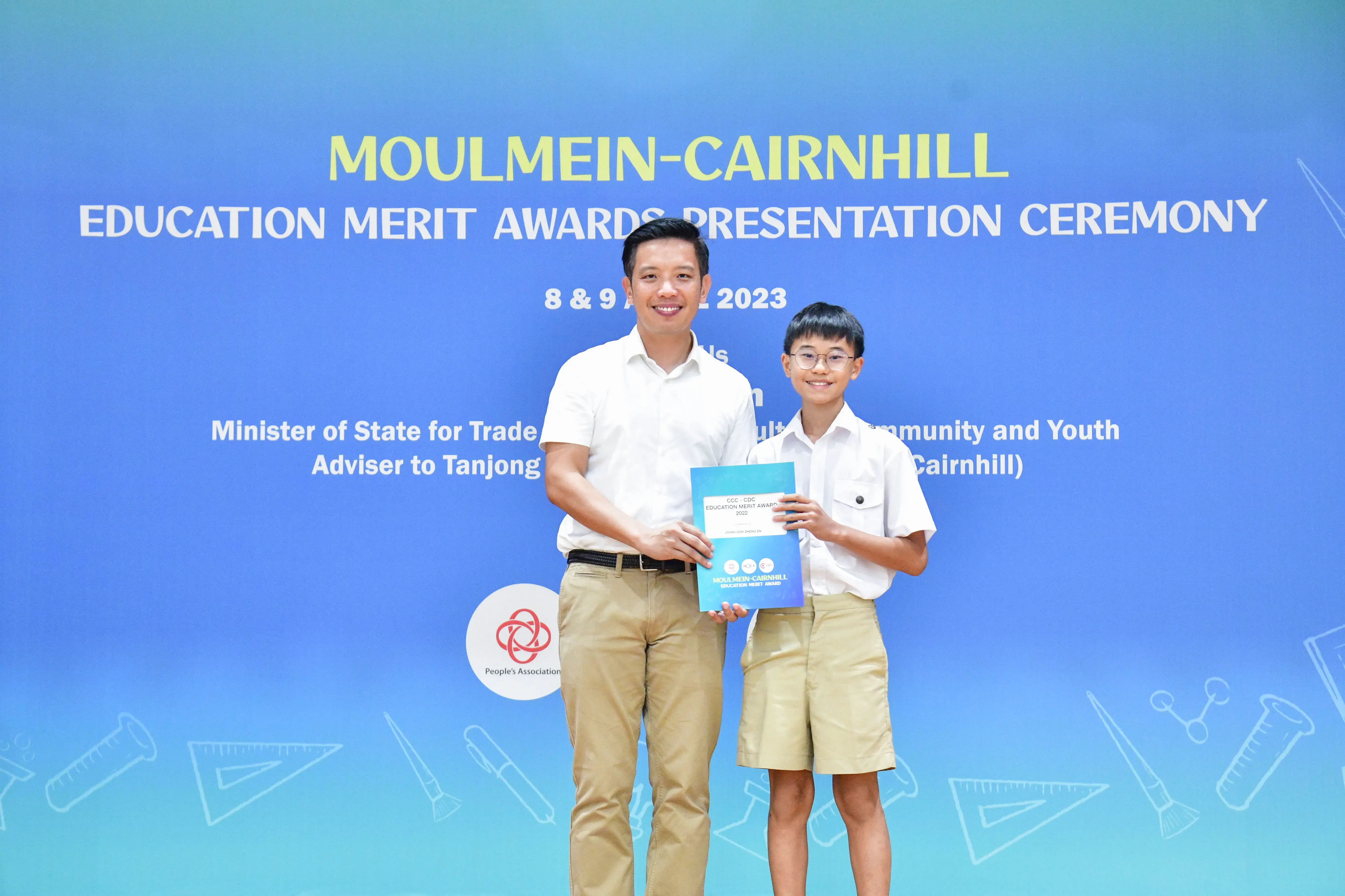 An adult and a young student holding an award certificate at the Moulmein-Cairnhill Education Merit Awards 2023.