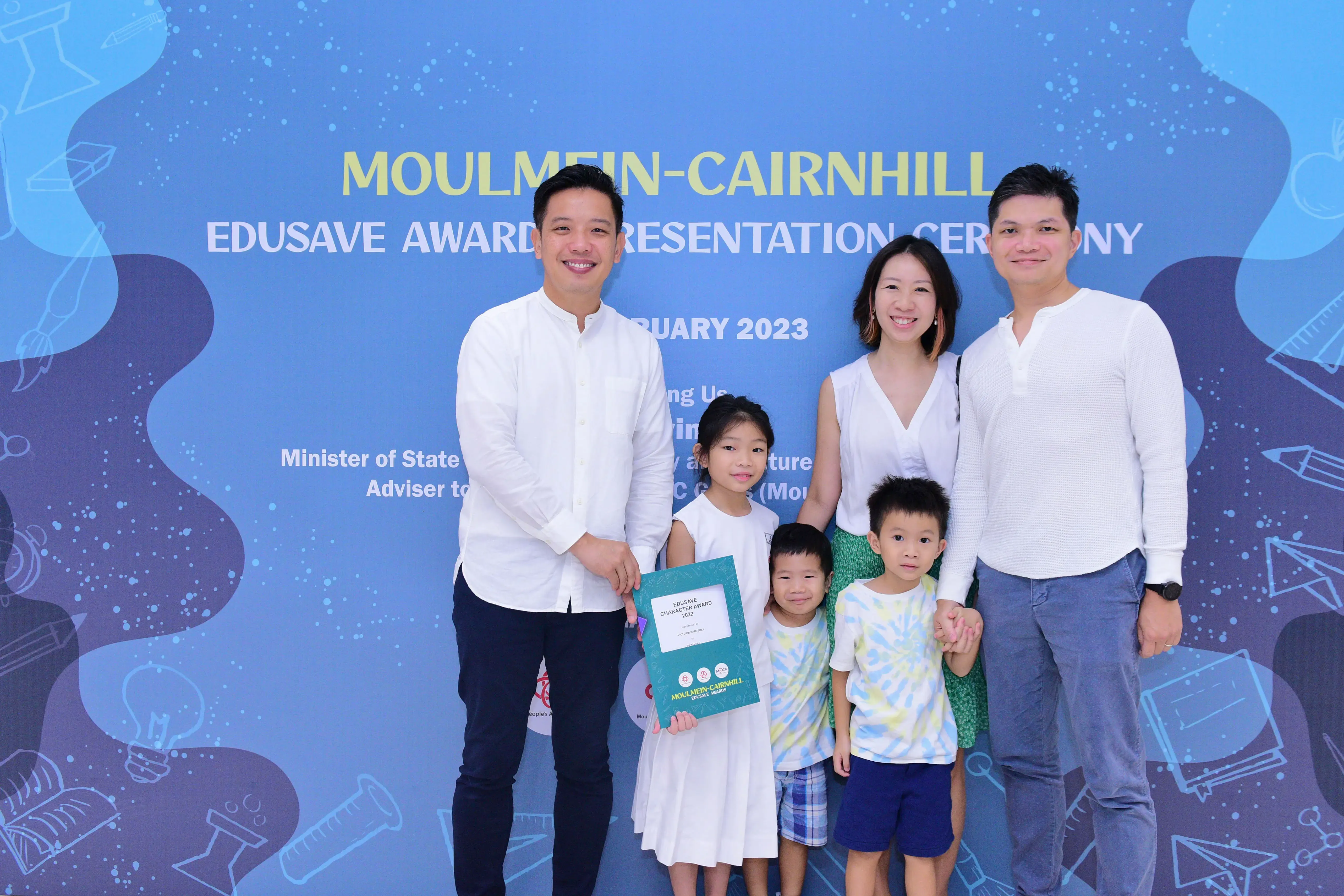 Two adults and three children pose at the Moulmein-Cairnhill Edusave Award Presentation Ceremony 2023.