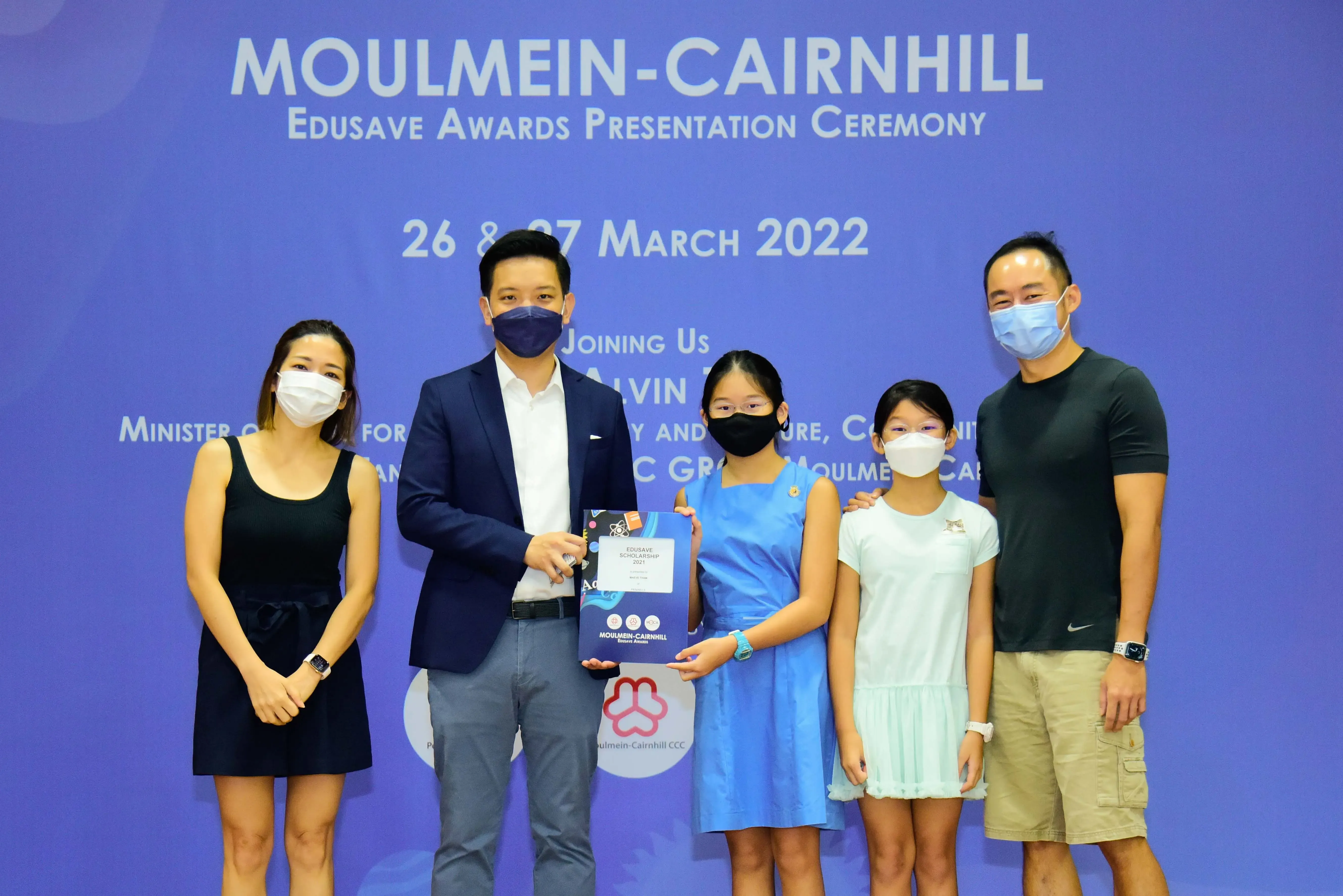 Five masked people pose at the Moulmein-Cairnhill Edusave Awards Presentation Ceremony on 26-27 March 2022.