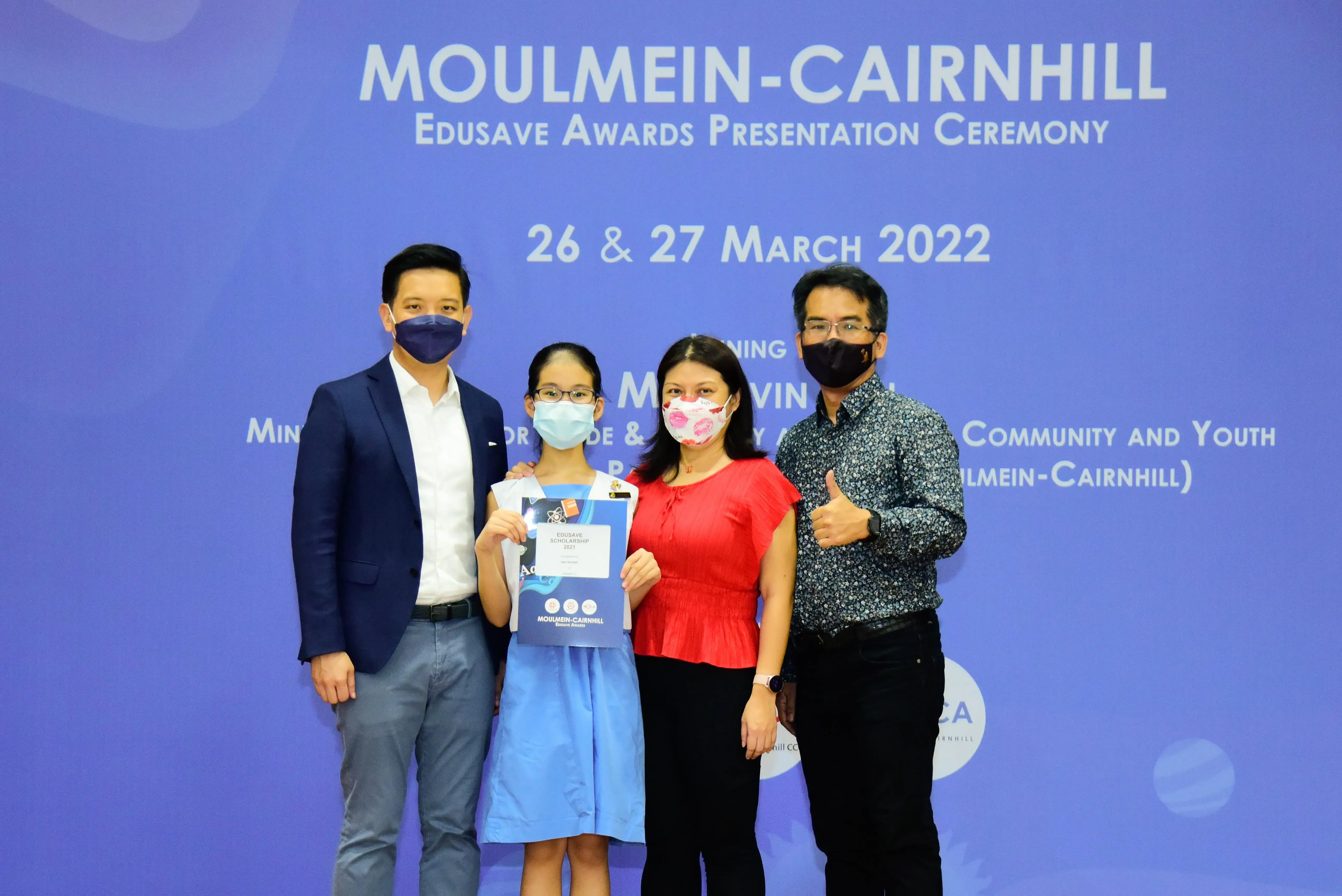 Four masked people pose at the Moulmein-Cairnhill Edusave Awards Presentation Ceremony on 27 March 2022.