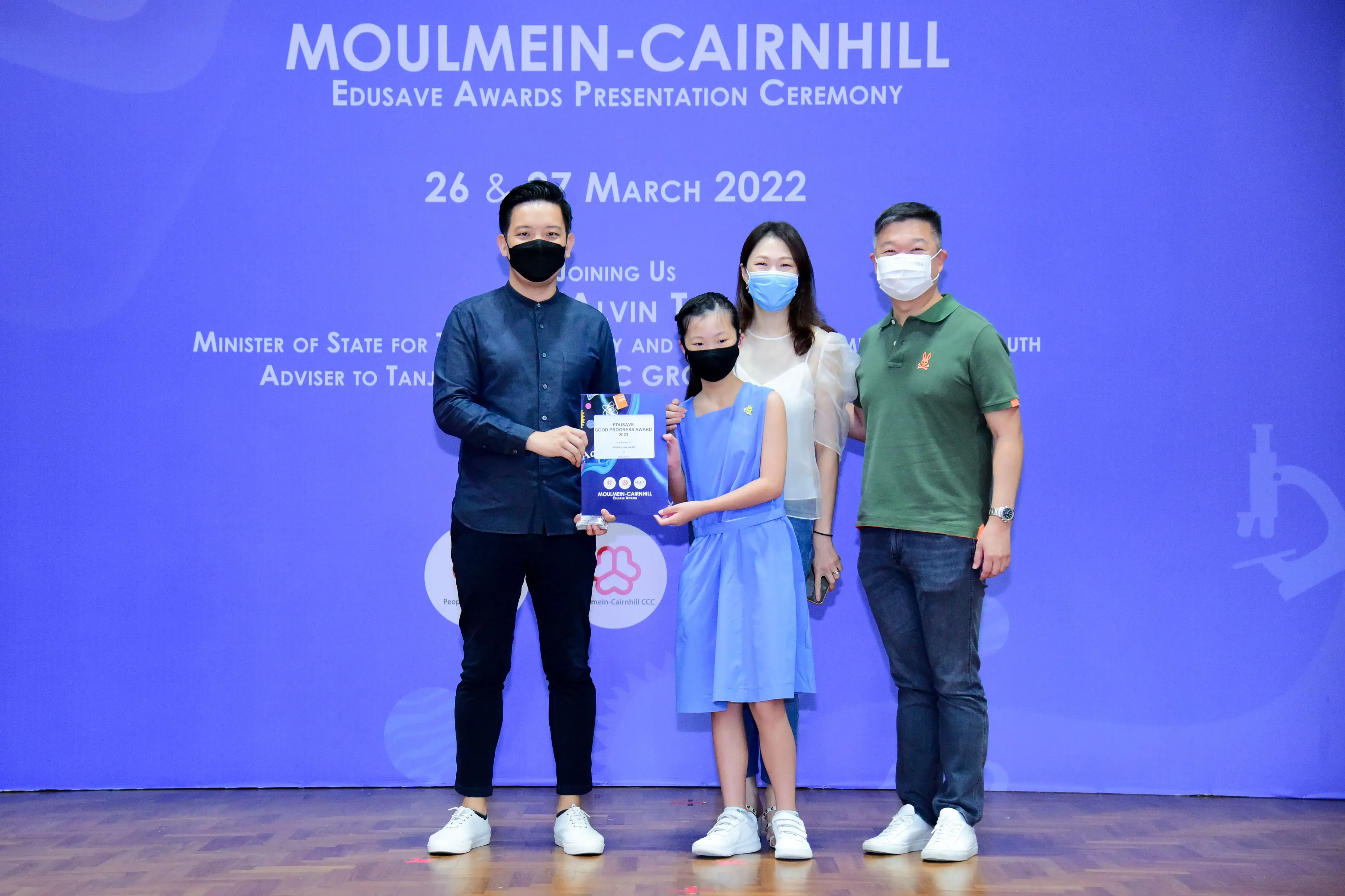Four masked people pose at the Moulmein-Cairnhill Edusave Awards Presentation Ceremony on 26-27 March 2022.