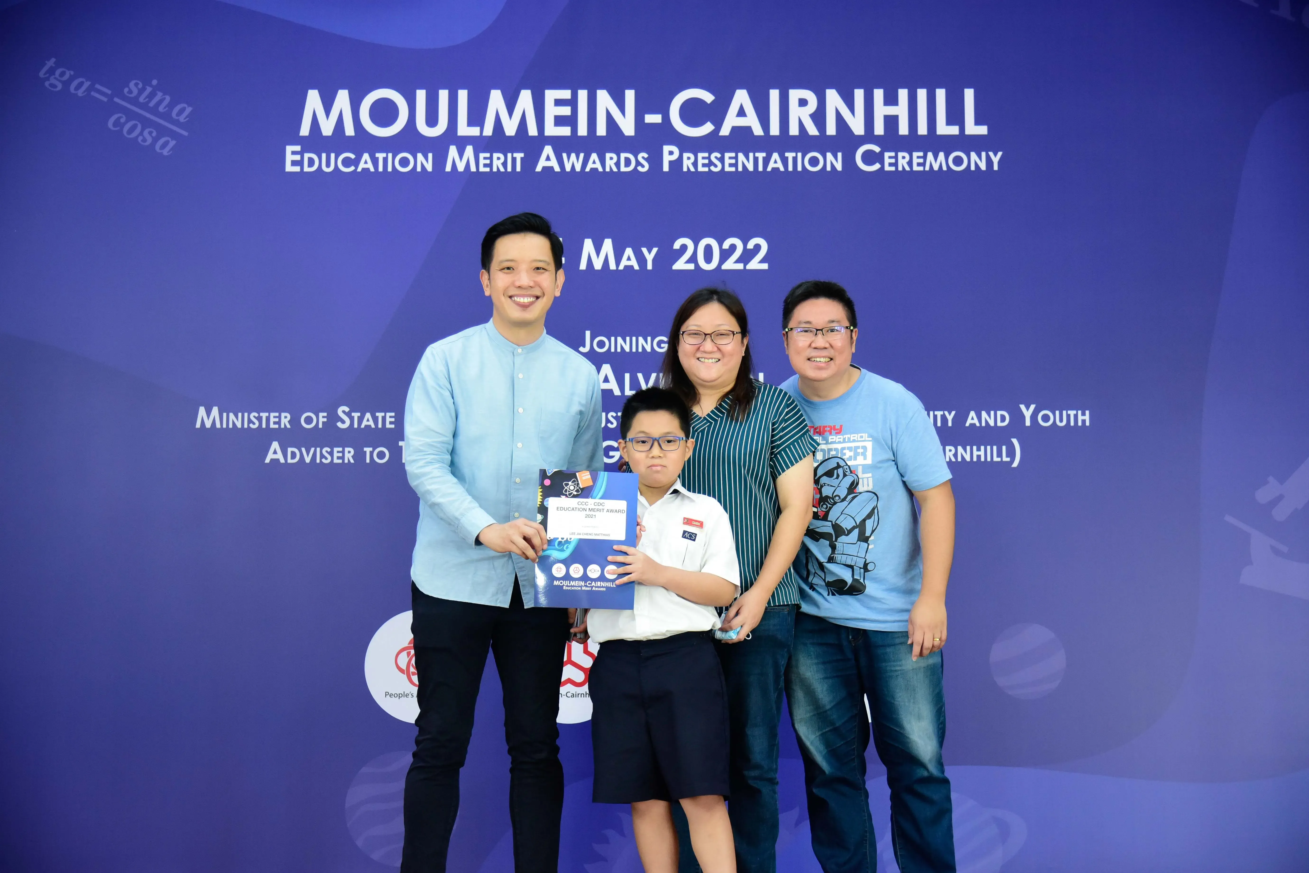 Three adults and a boy holding an award certificate pose at the Moulmein-Cairnhill Education Merit Awards May 2022.