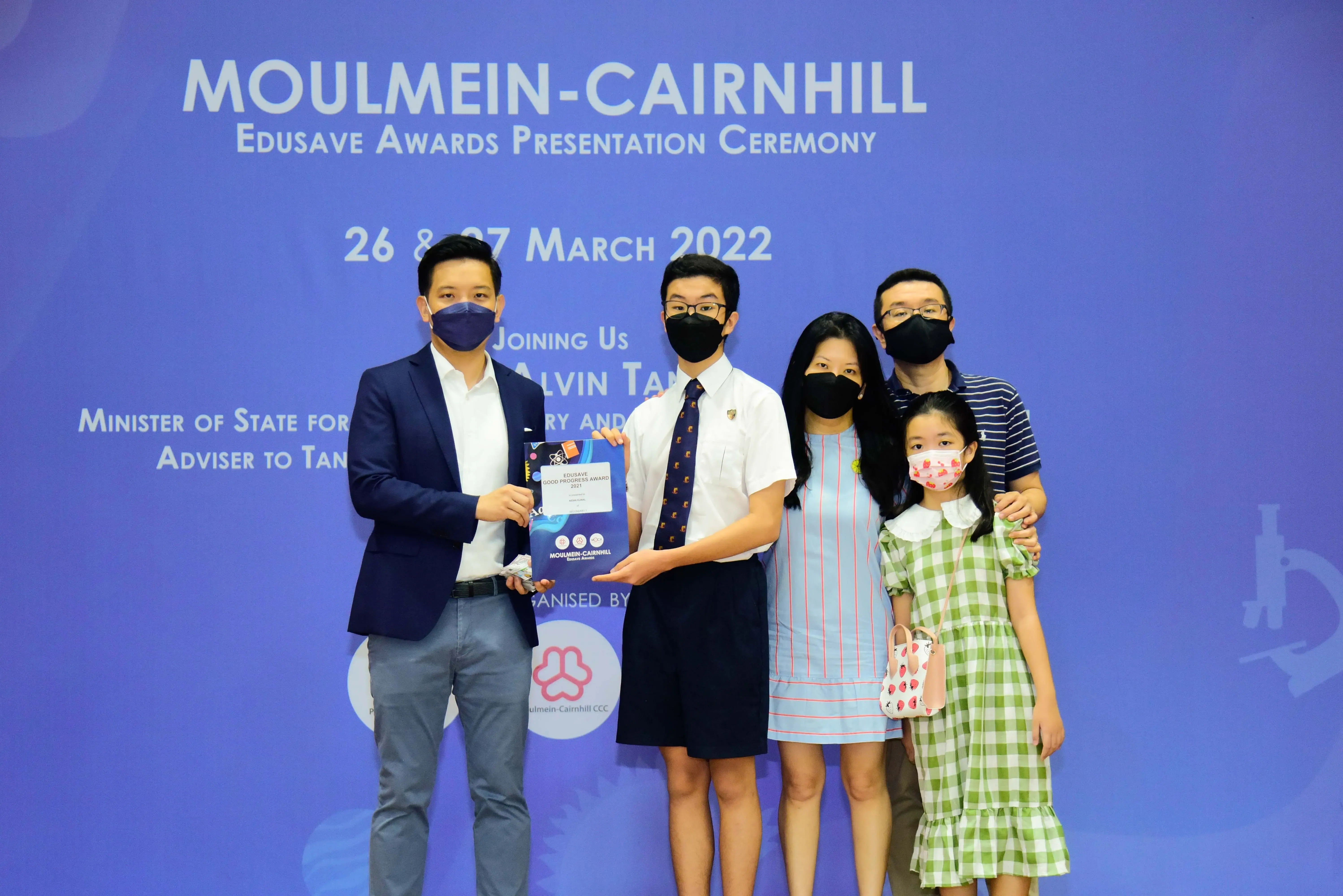 Five masked people pose at the Moulmein-Cairnhill Edusave Awards Presentation Ceremony on 26-27 March 2022.