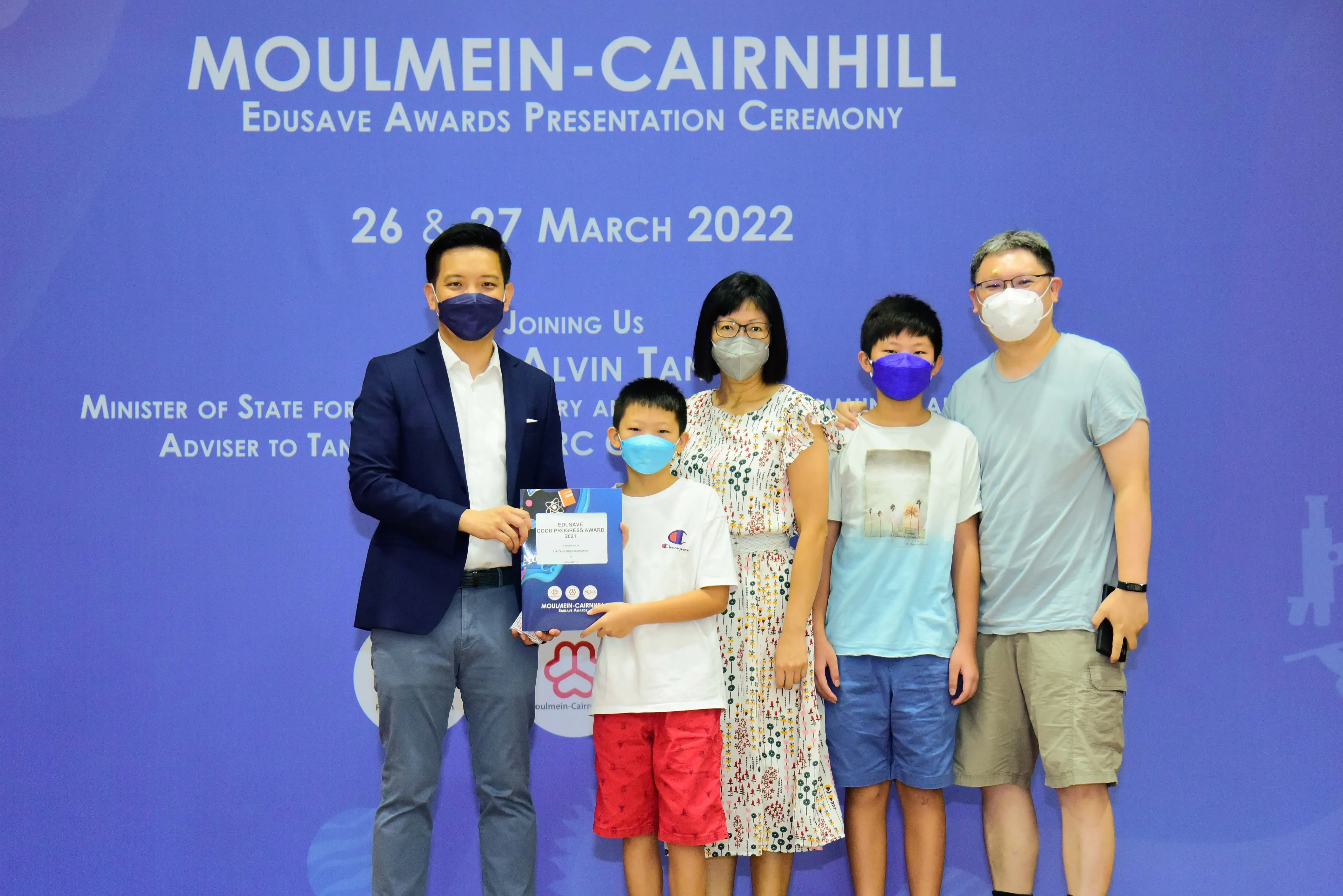 Five masked people pose at the Moulmein-Cairnhill Edusave Awards Presentation Ceremony on 26-27 March 2022.