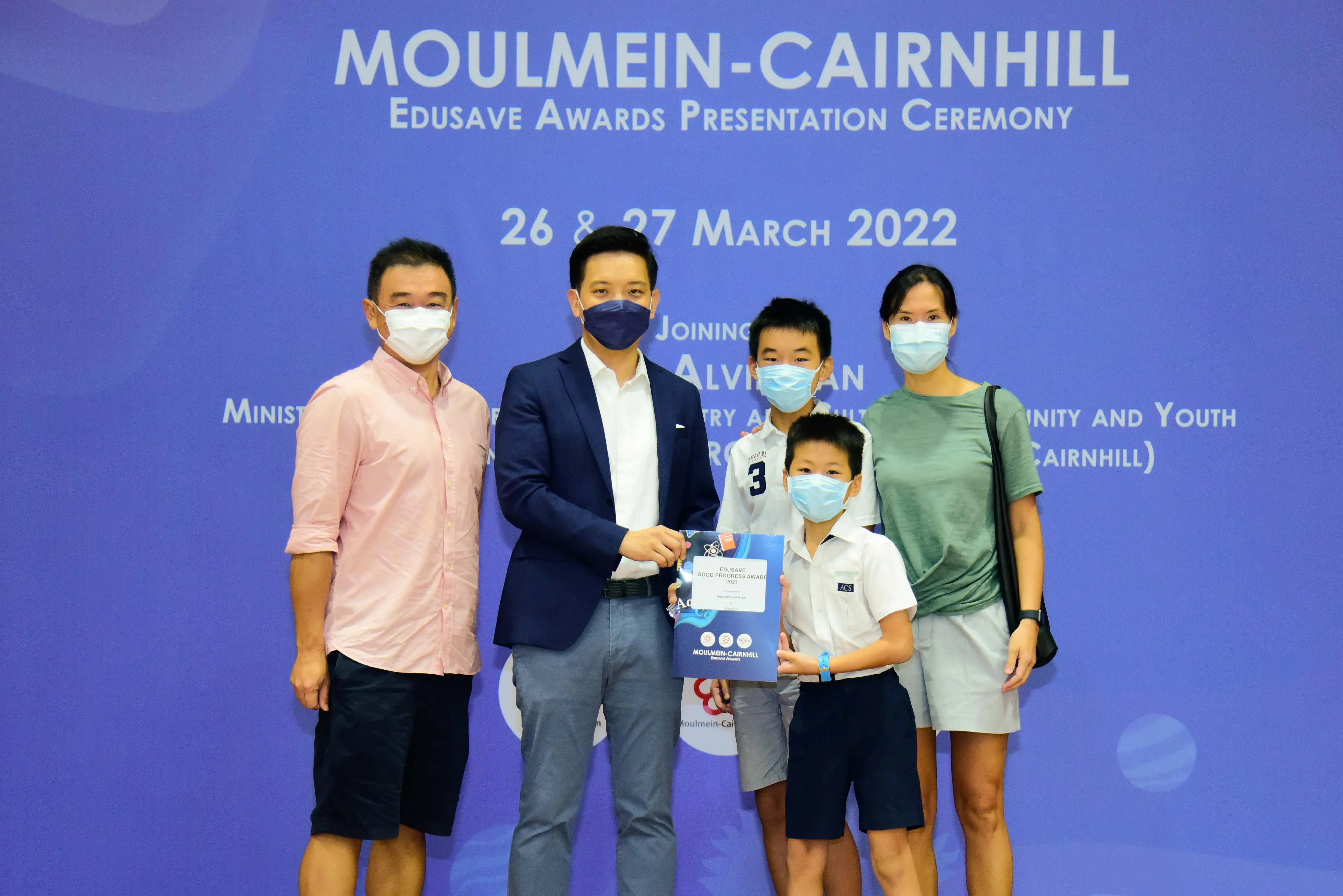 Five masked people pose at the Moulmein-Cairnhill Edusave Awards Presentation Ceremony on 26-27 March 2022.