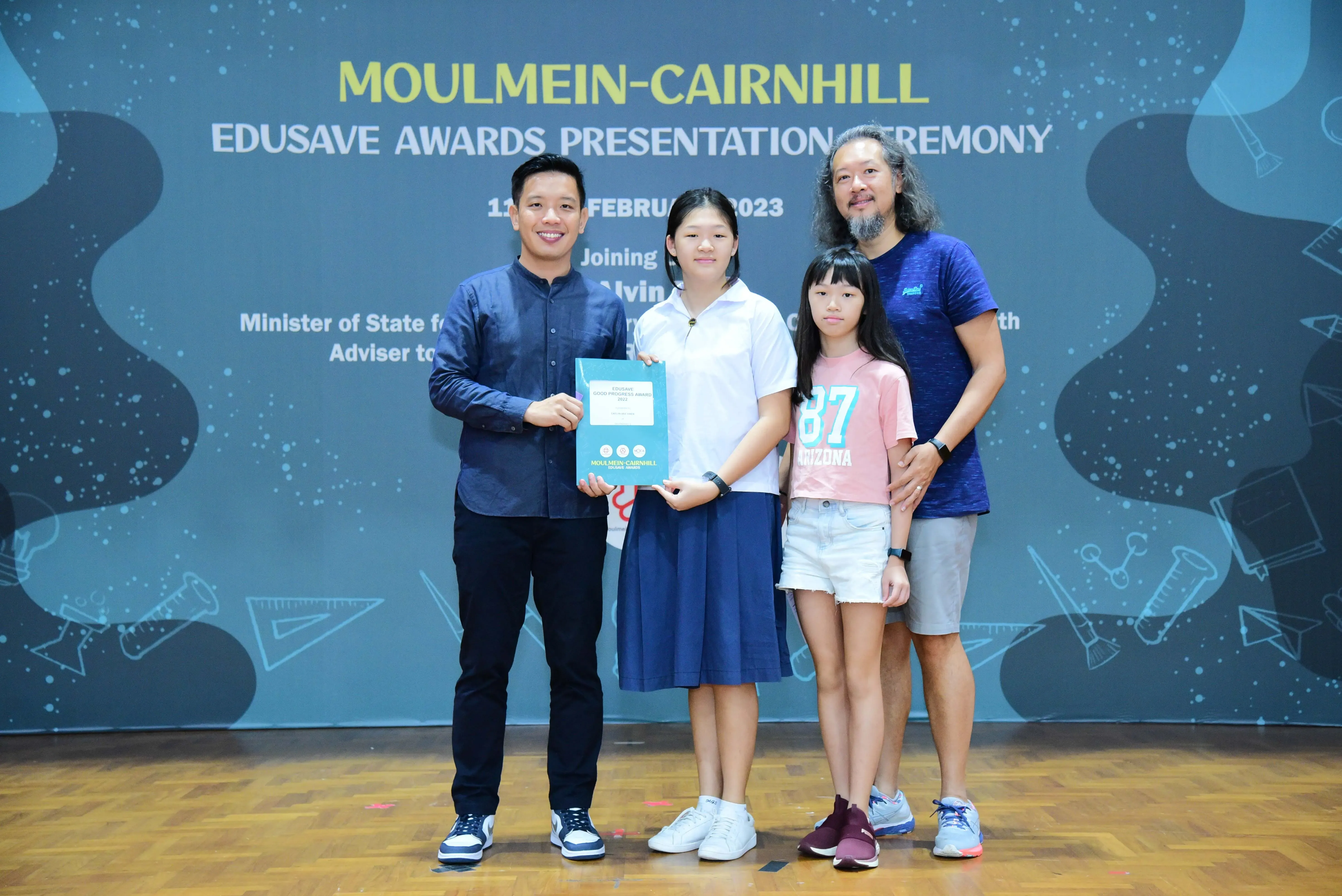 Four people pose with an award at the Moulmein-Cairnhill Edusave Awards Presentation Ceremony in February 2023.