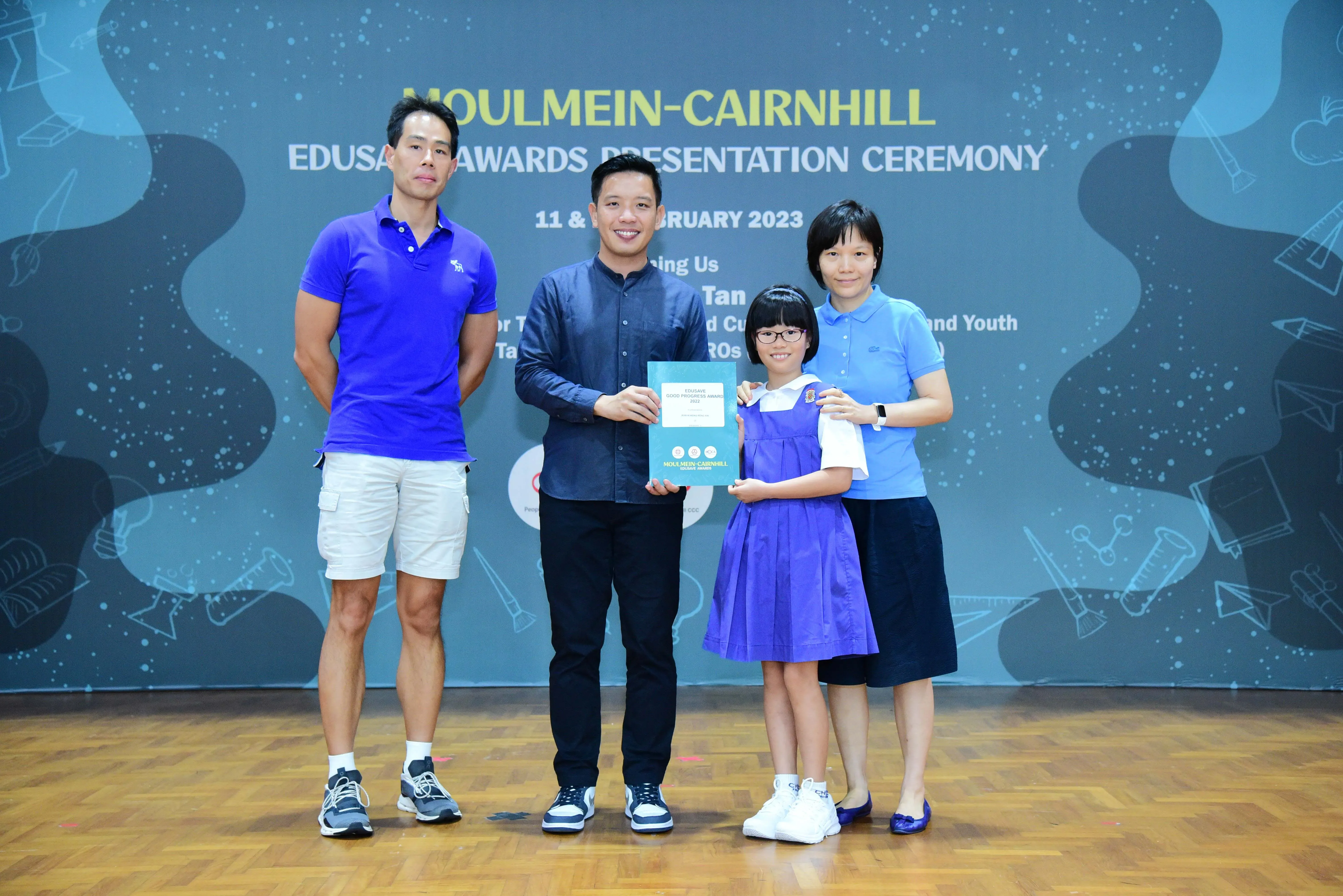 Four people pose with a certificate at the Moulmein-Cairnhill Edusave Awards Presentation Ceremony, February 2023.